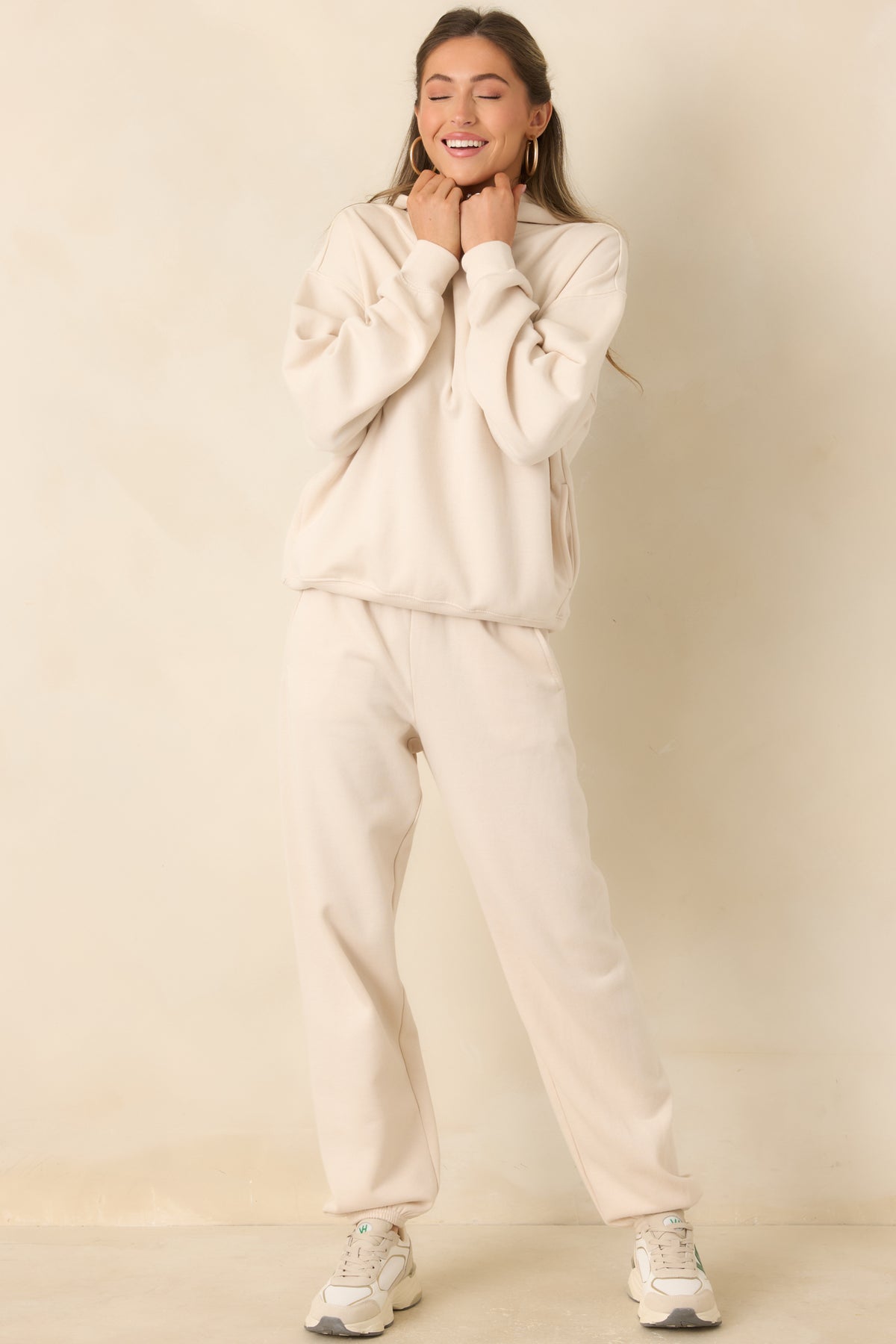Ivory-beige joggers with an elastic waistband, practical pockets, and softly gathered hems.