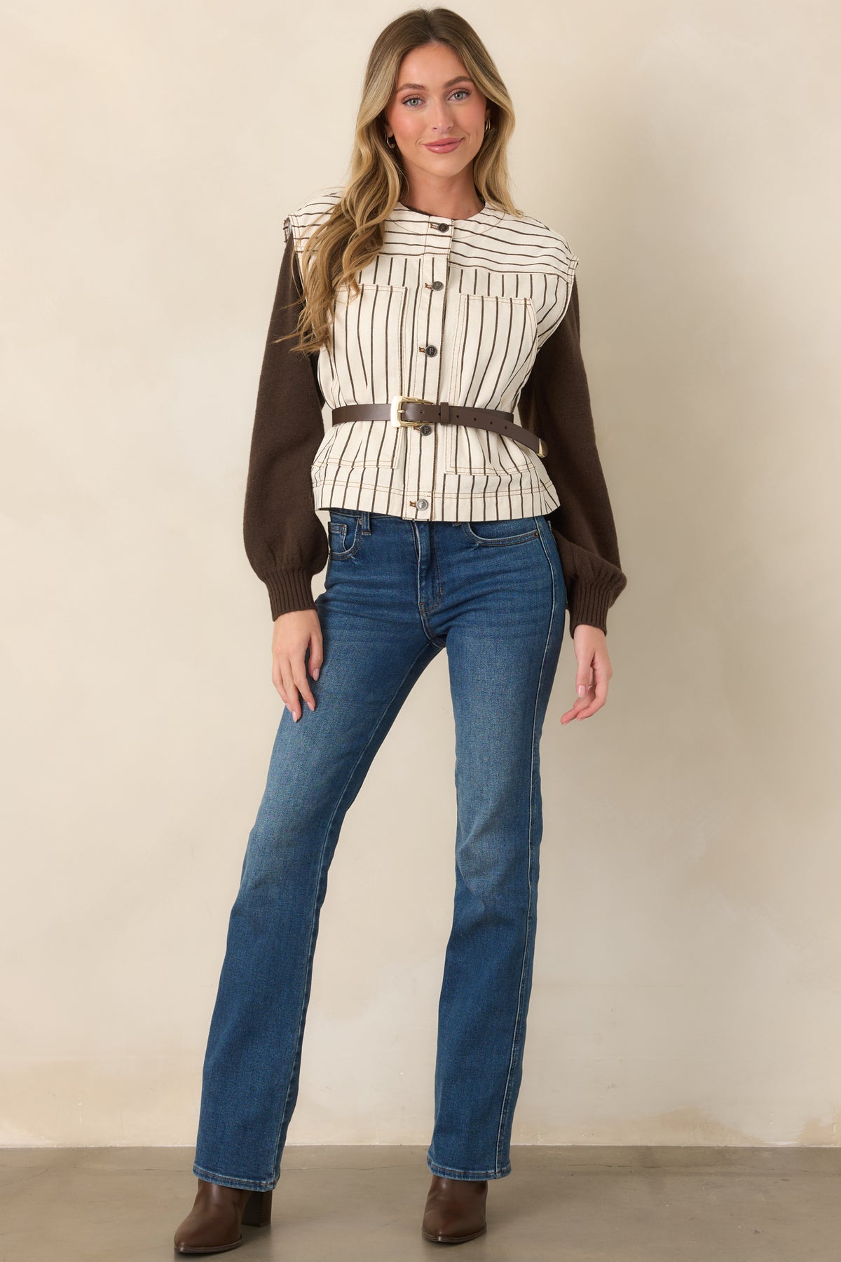 Ivory cotton vest with slim brown pinstripes, cap-style shoulders, oversized patch pockets, and a relaxed boxy silhouette.