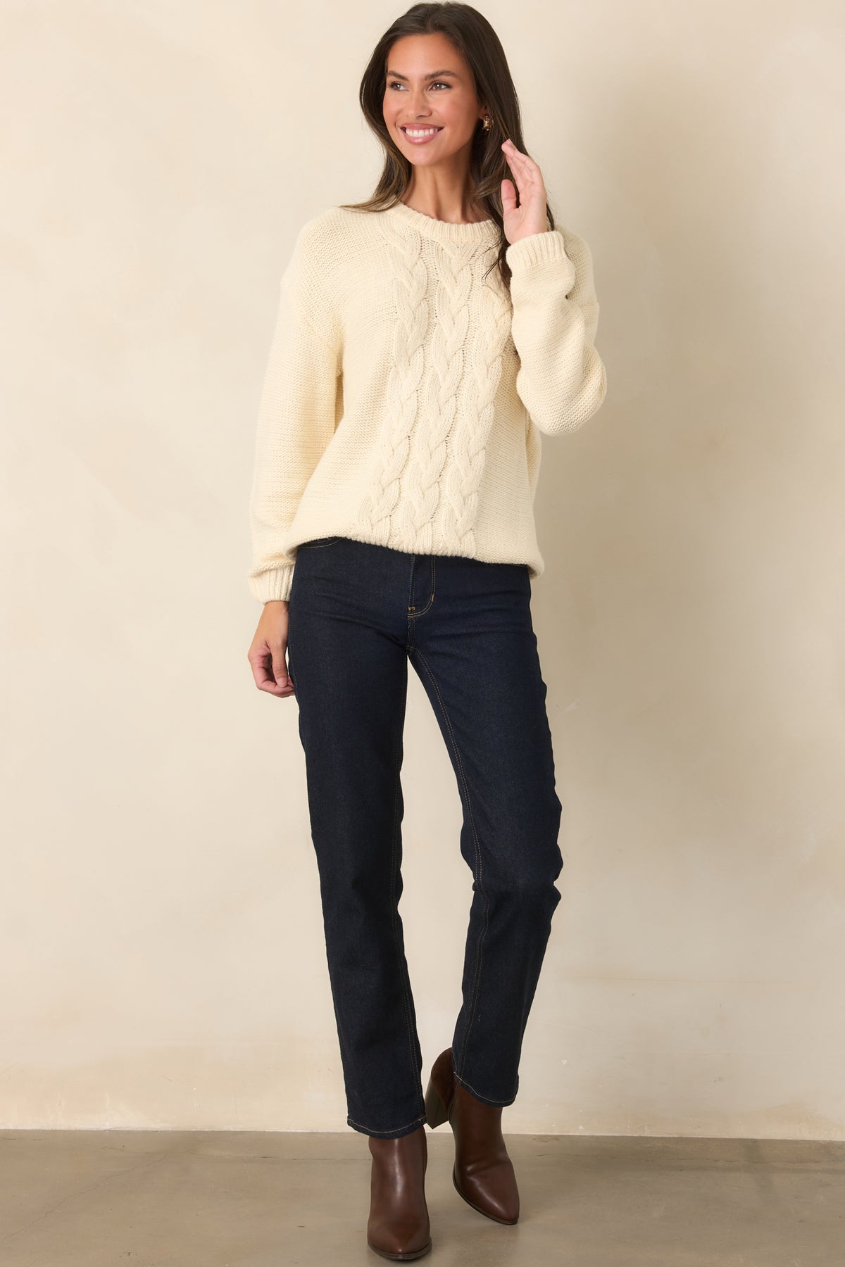 Ivory cable knit sweater with long sleeves, a crew neckline, and a comfortable pullover design.