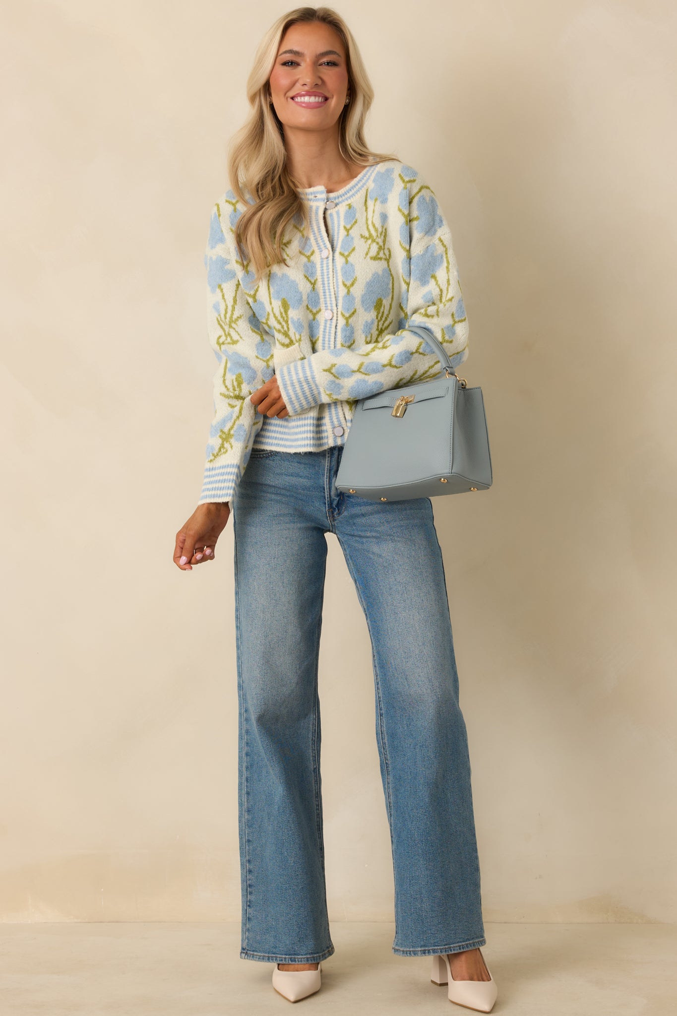 Relaxed-fit ivory cardigan with allover floral design, front patch pockets, and button-front detail.
