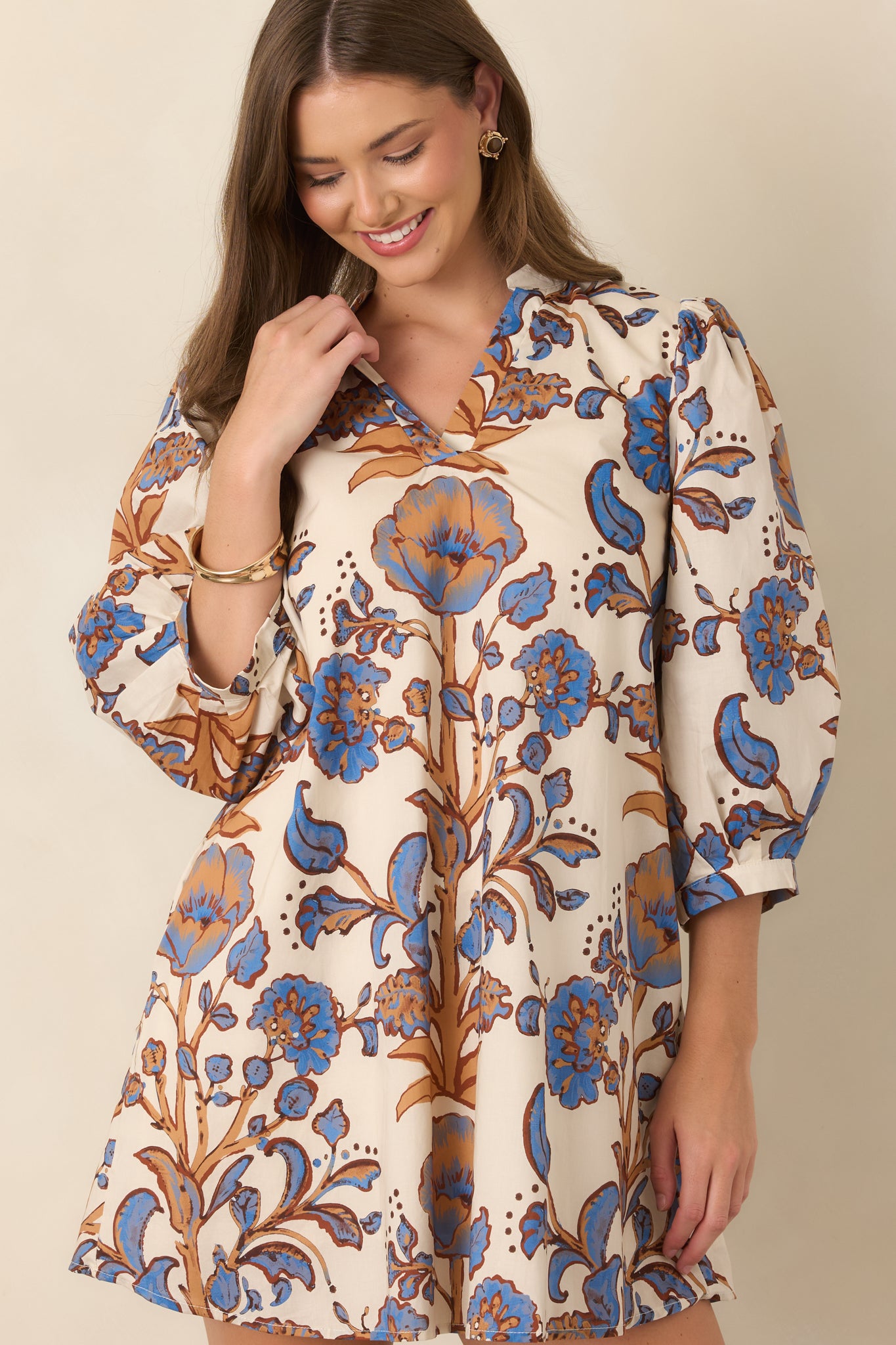 Detailed view of the ivory cotton fabric showcasing blue florals with contrasting camel and brown accents.