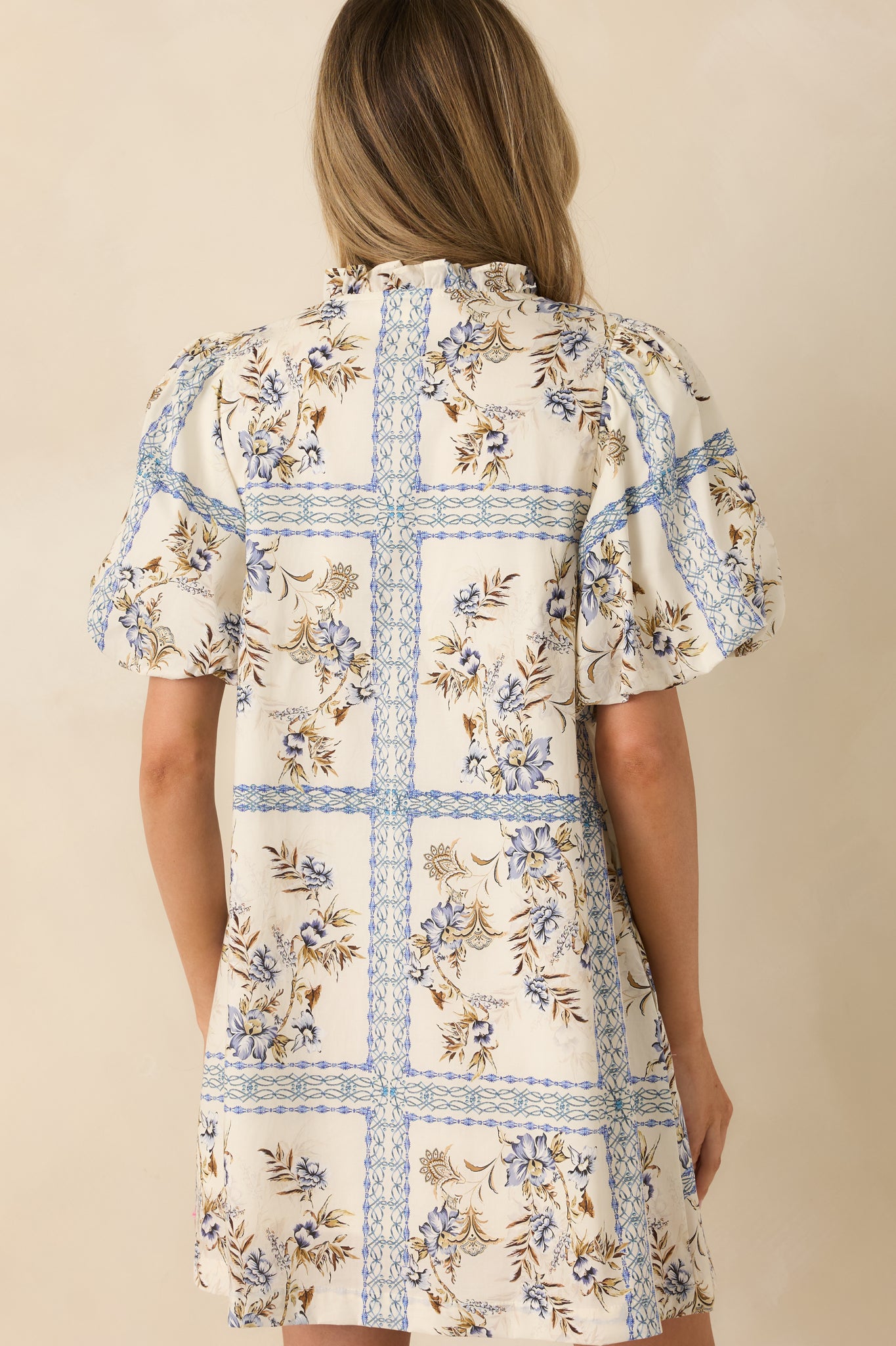 Ivory cotton mini dress with the blue and neutral floral print continuing across the rear.