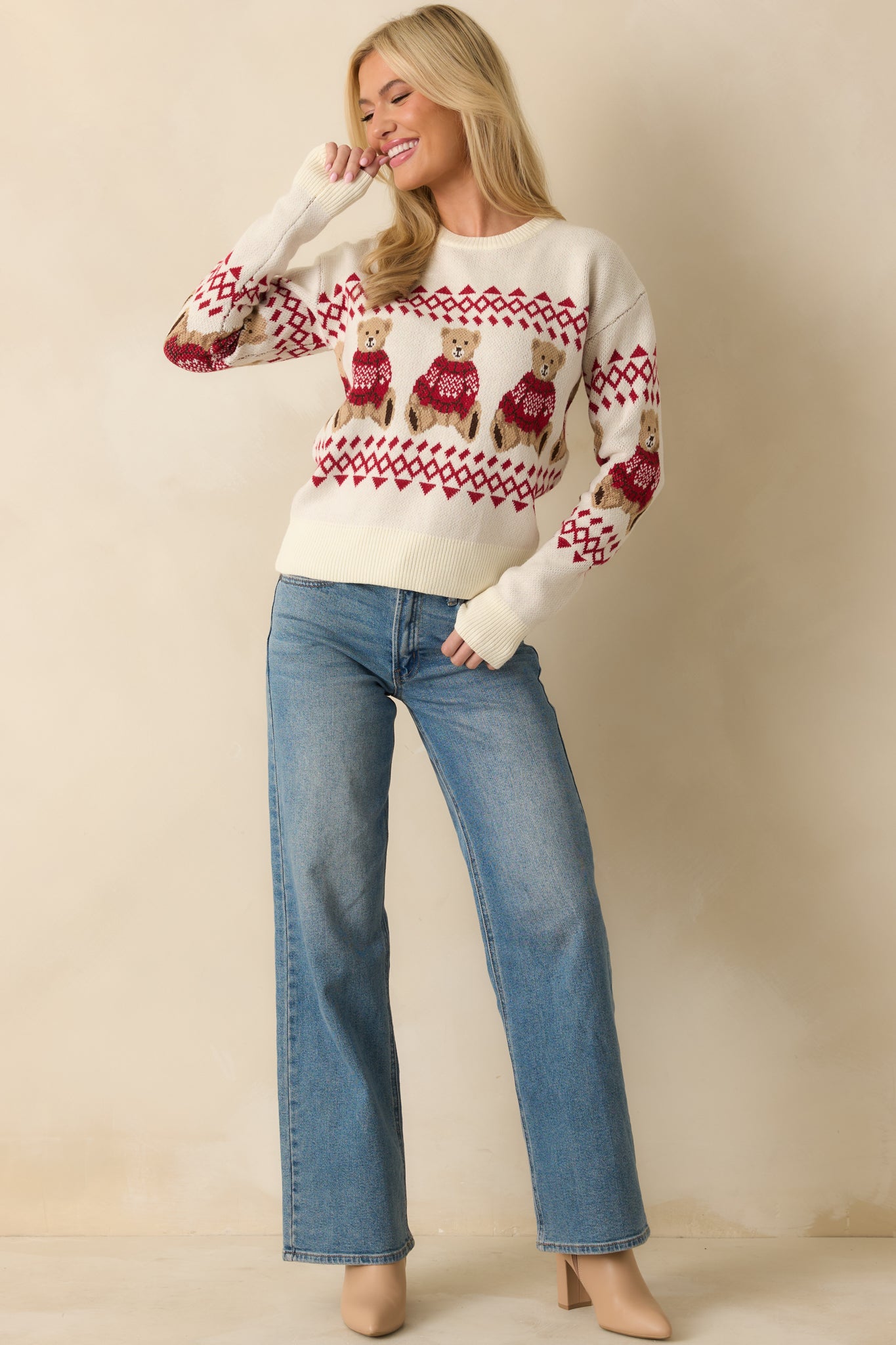Classic crewneck ivory sweater with ribbed edges and seasonal teddy bear and fair isle motifs throughout the fabric.