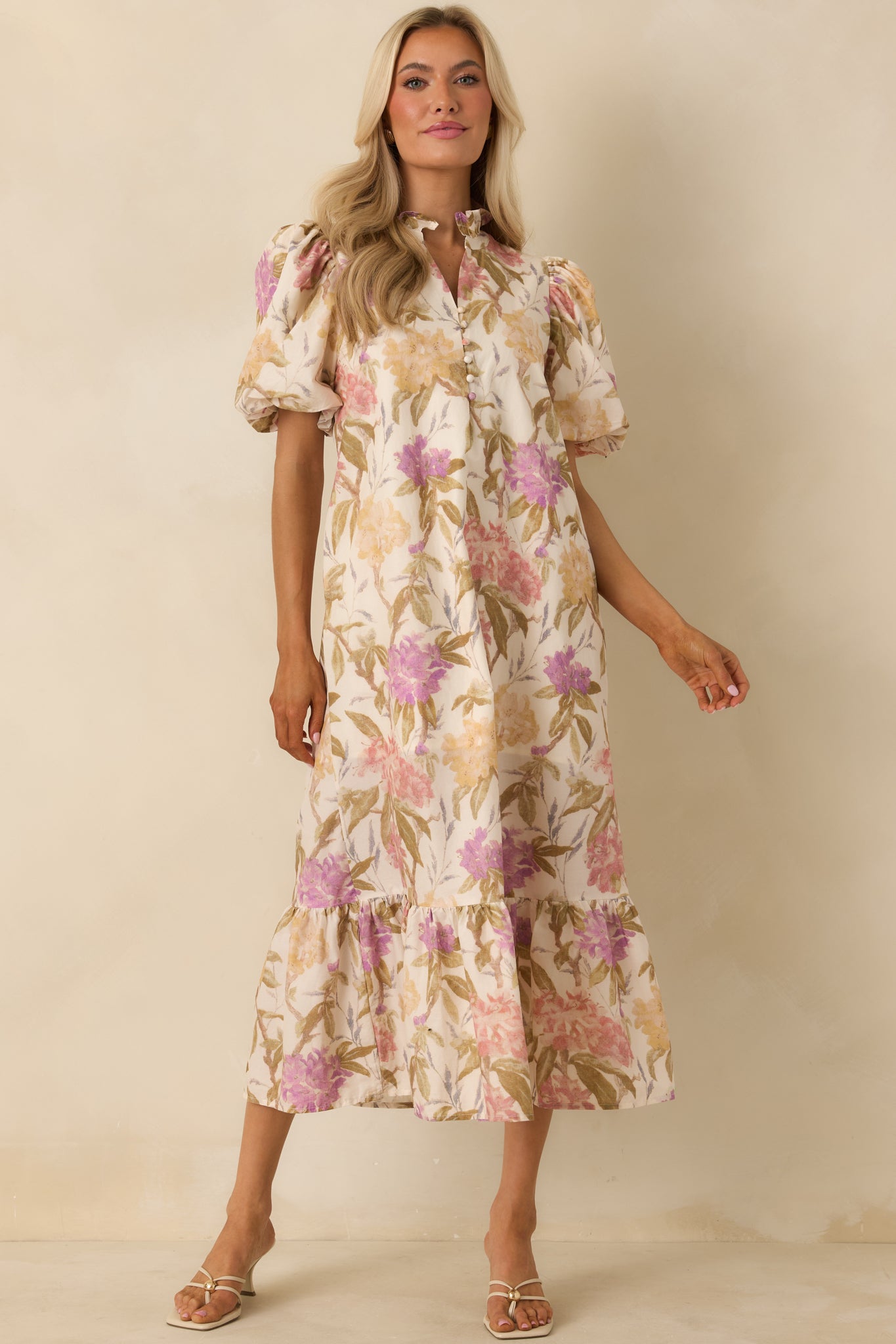 Ivory multi floral midi dress with a relaxed fit, short puff sleeves, and a ruffled stand collar. Finished with a partial button placket, side pockets, and a softly gathered ruffle hem for a breezy look.