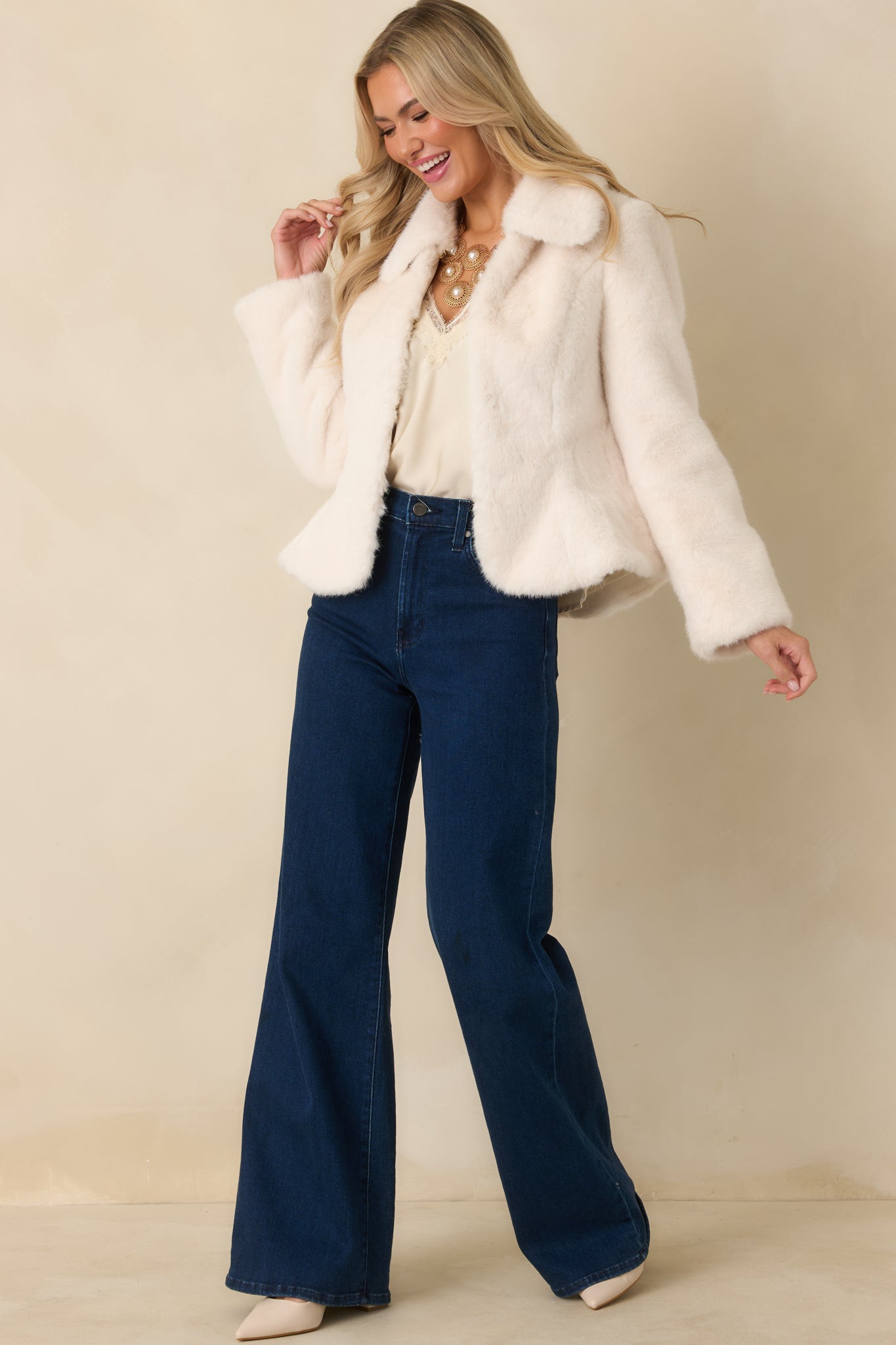 Ivory faux fur coat with long sleeves and a tailored body, offering a sleek, structured look with minimal bulk.