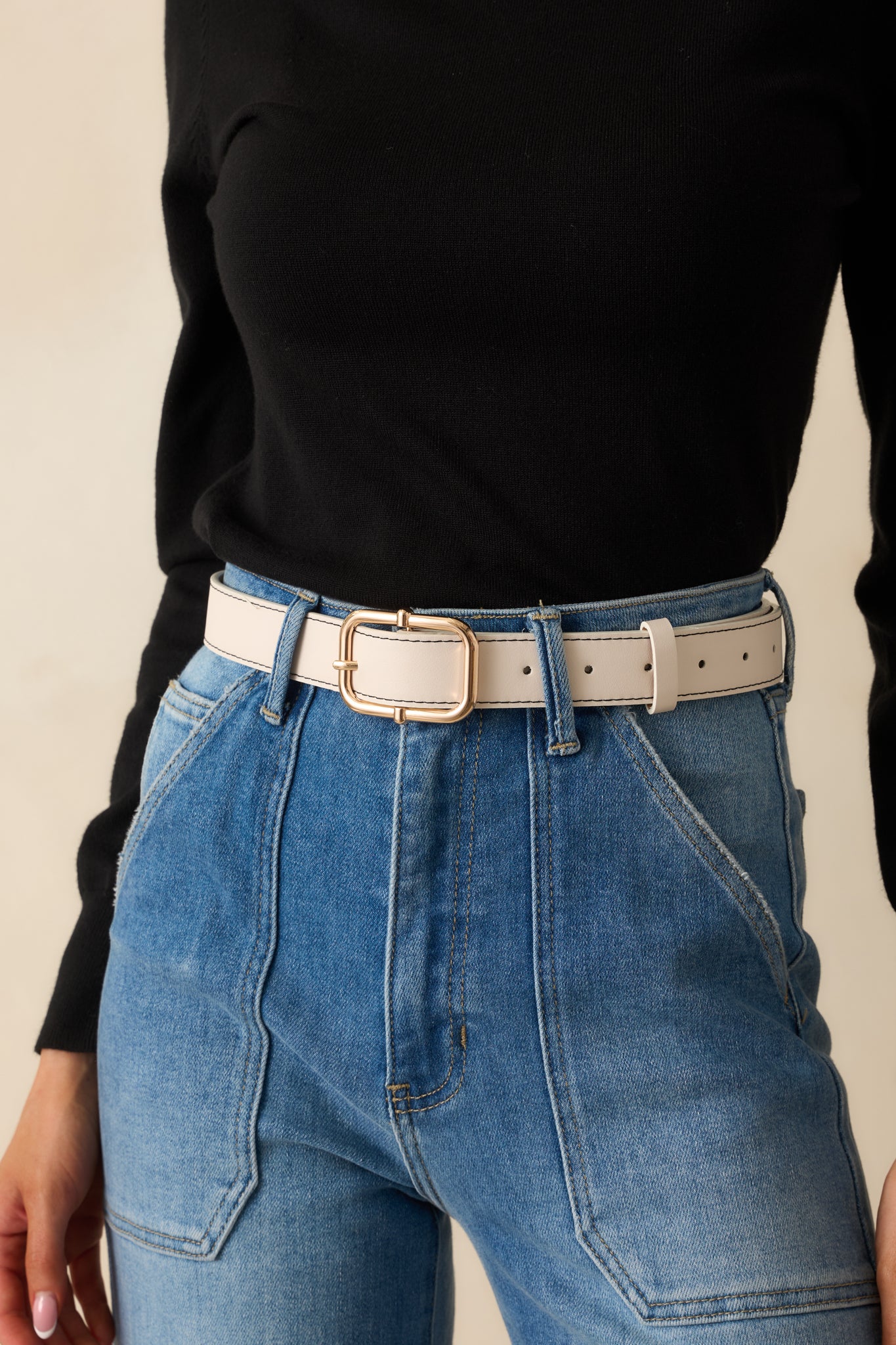 Ivory faux leather belt highlighting the gold square pin buckle and stitched border.