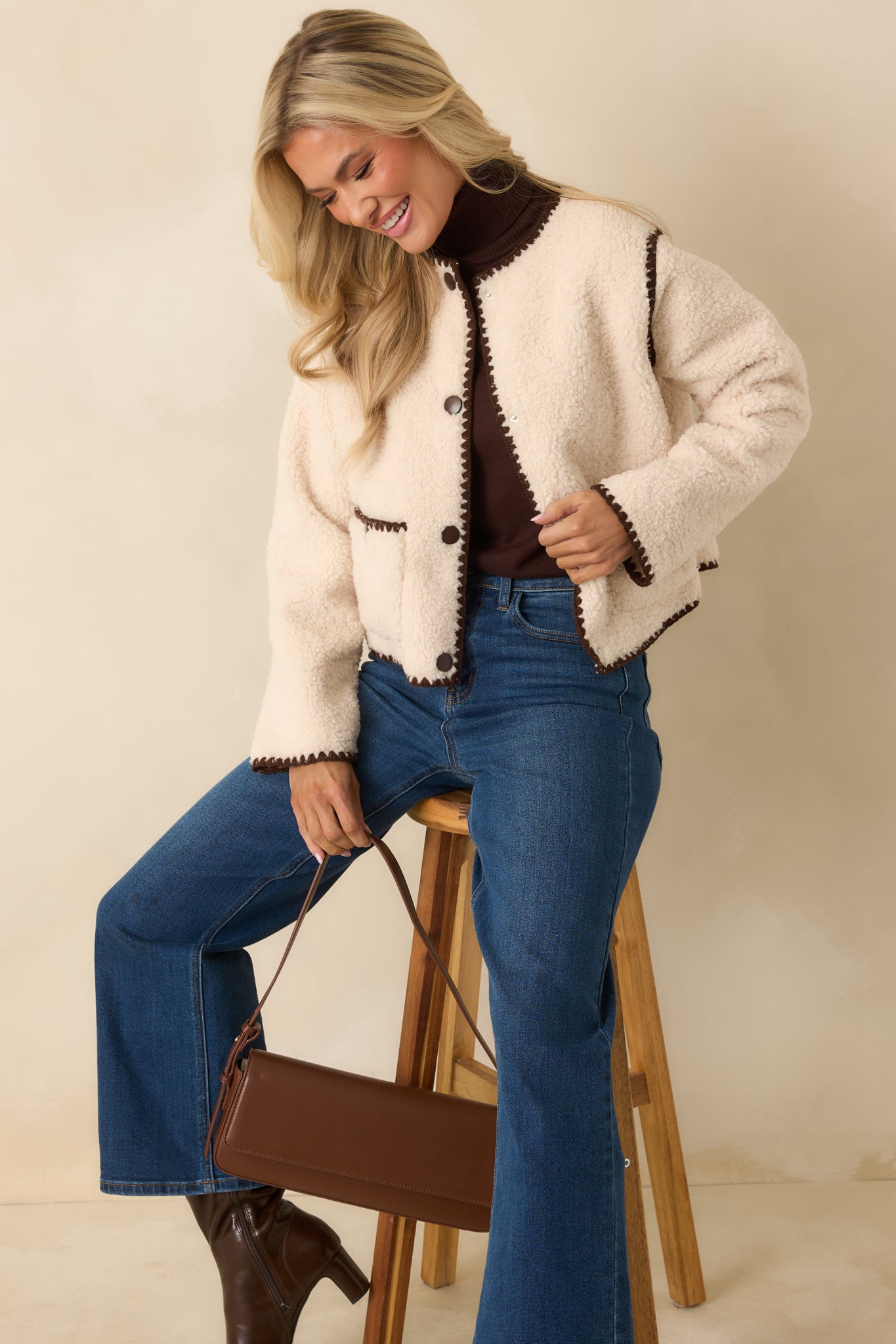 Ivory faux sherpa jacket presented with its plush texture and softly structured, hip-length fit.