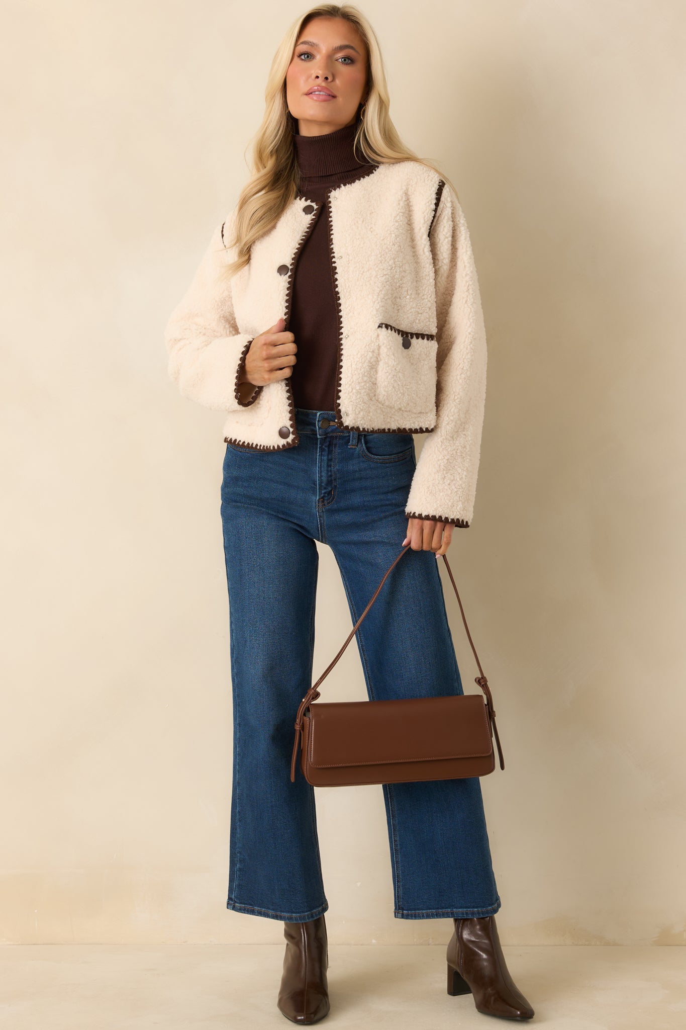 Ivory faux sherpa jacket showing its plush texture and relaxed, hip-length shape.
