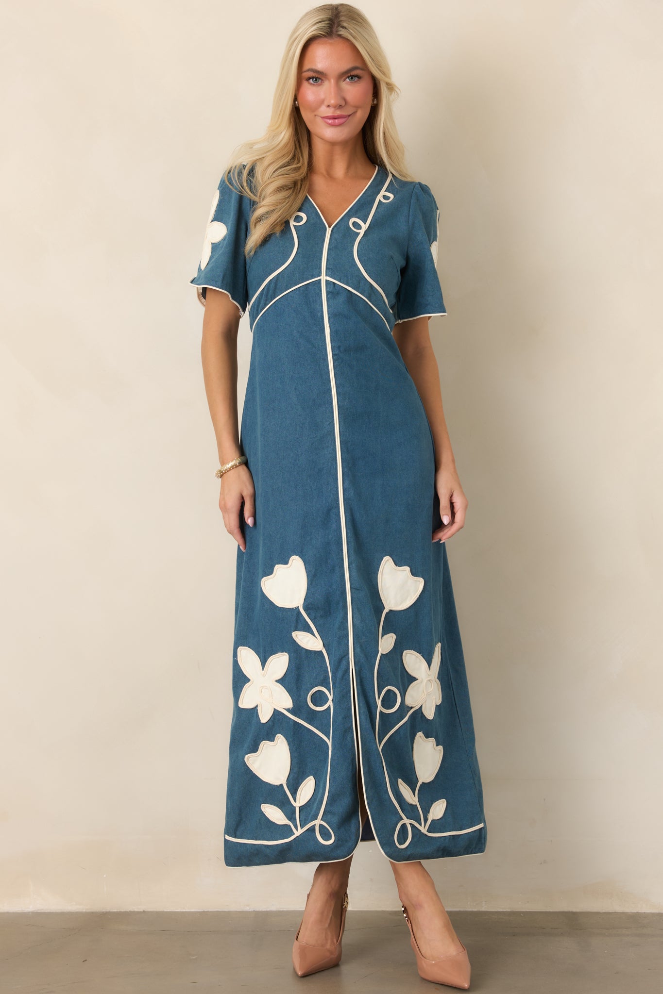 Maxi dress showcasing delicate ivory floral appliqué and matching piping that trace the silhouette from neckline to hem.