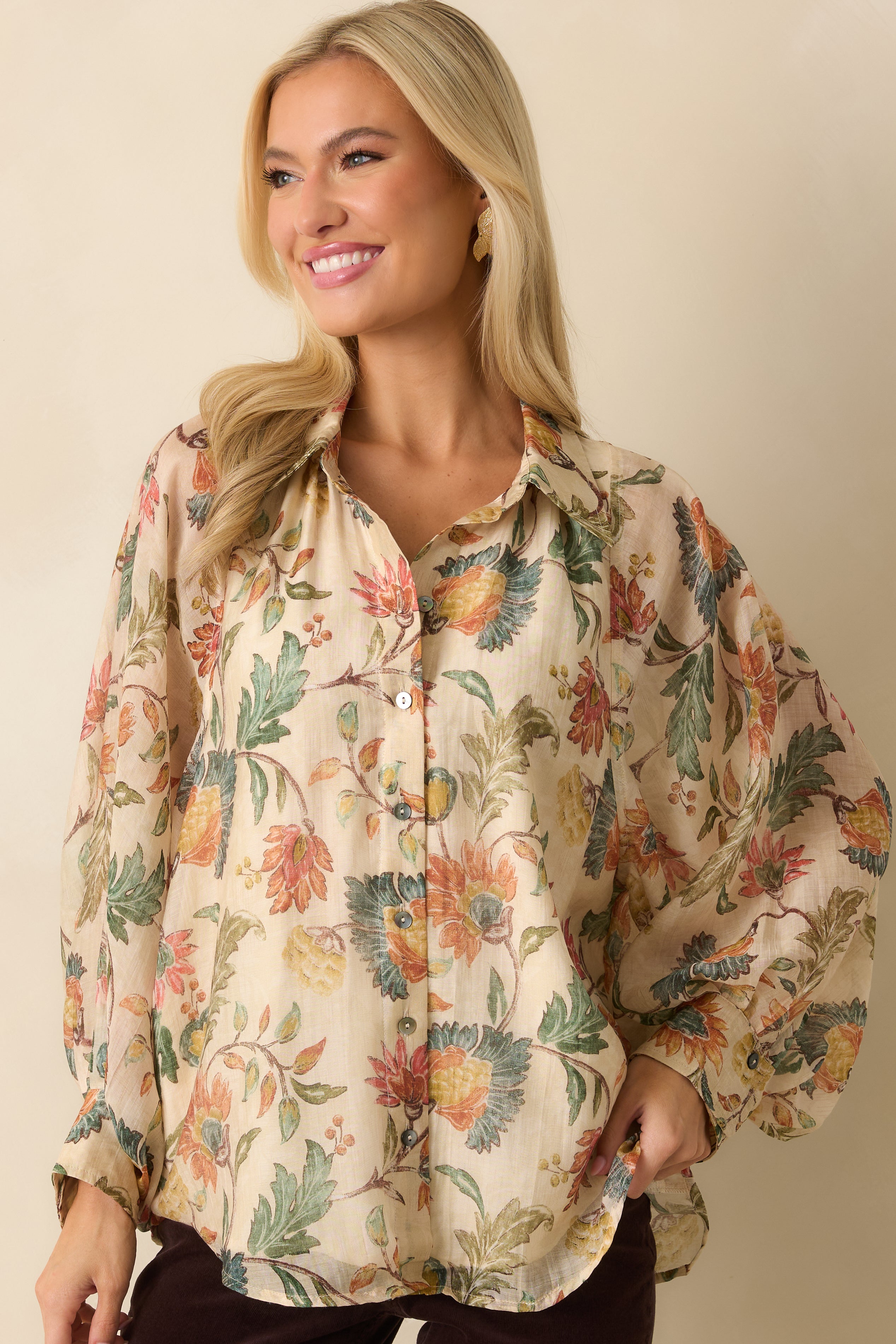 Front view highlighting the collared neckline and buttoned peasant sleeves on the ivory floral blouse.