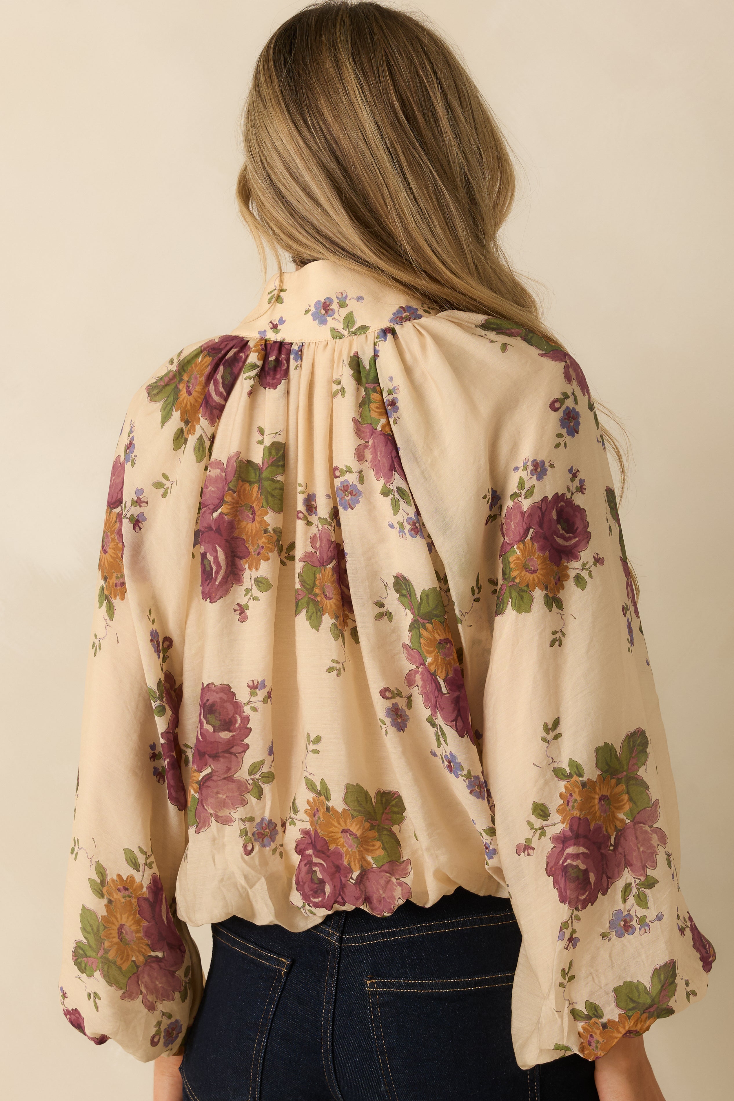 Rear view of the ivory multi floral blouse showing the relaxed silhouette and soft sleeve gathering.