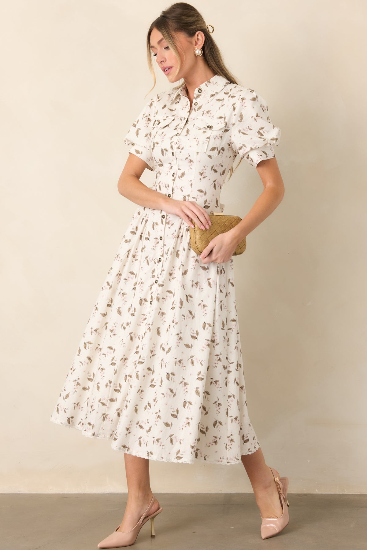 Ivory floral dress features a defined waist, flap chest pockets, gathered midi skirt, and delicate lace trim at the hem.
