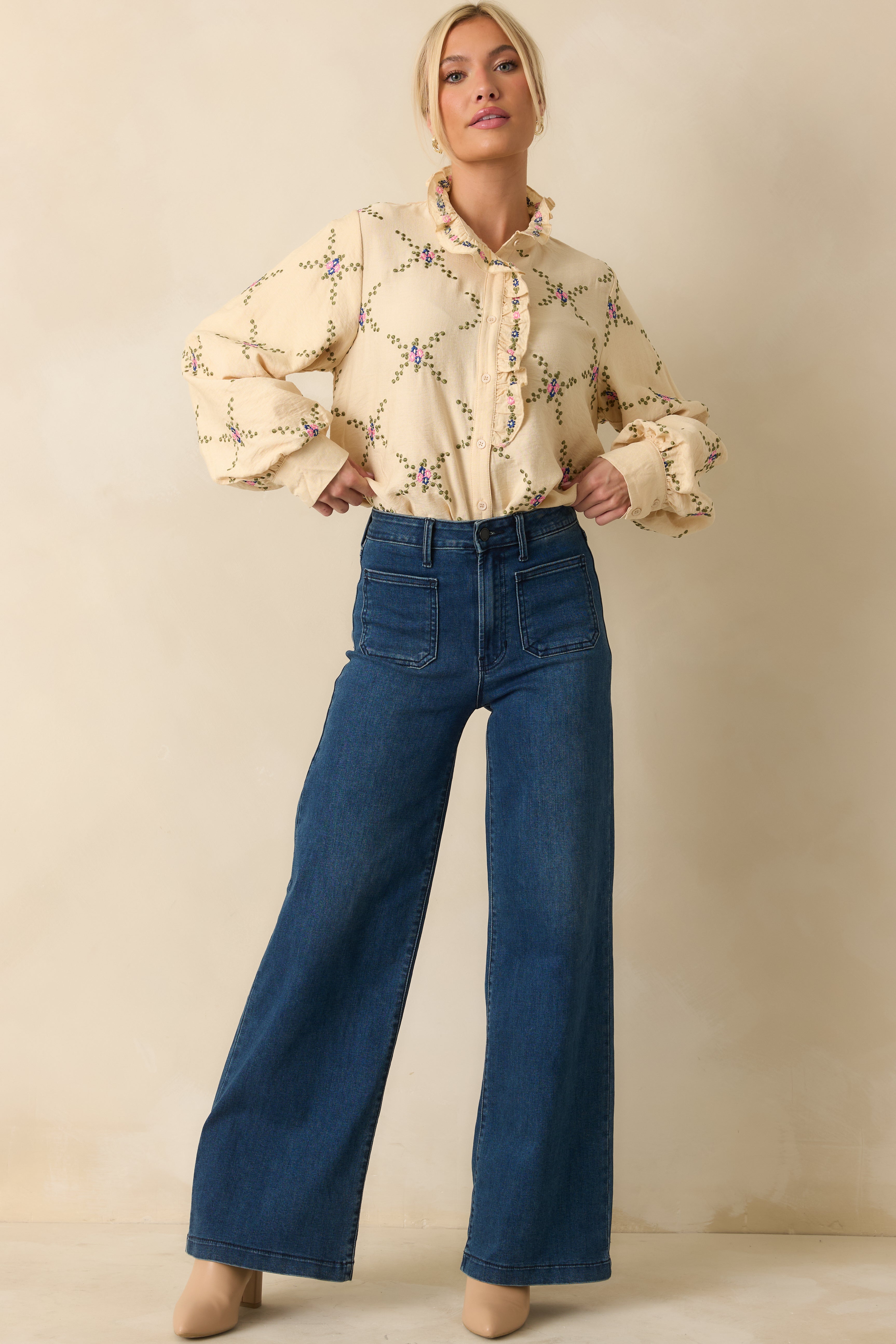 Ivory floral embroidered blouse with ruffled neckline and flowing balloon sleeves.