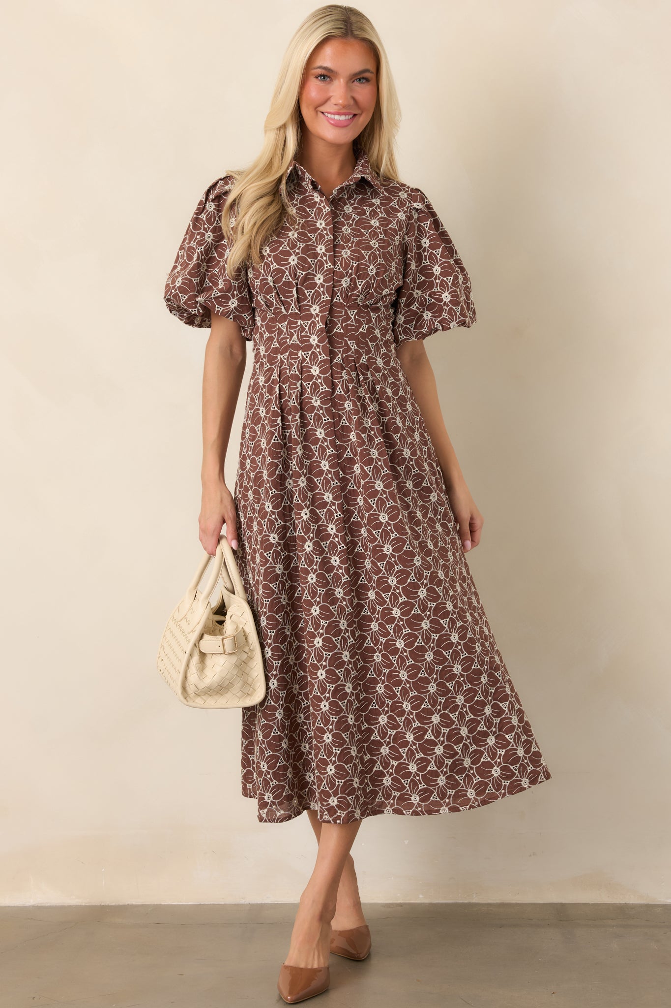 Ivory floral eyelet midi dress with a collared neckline, button-front closure, short puff sleeves, fitted waist, and full skirt.
