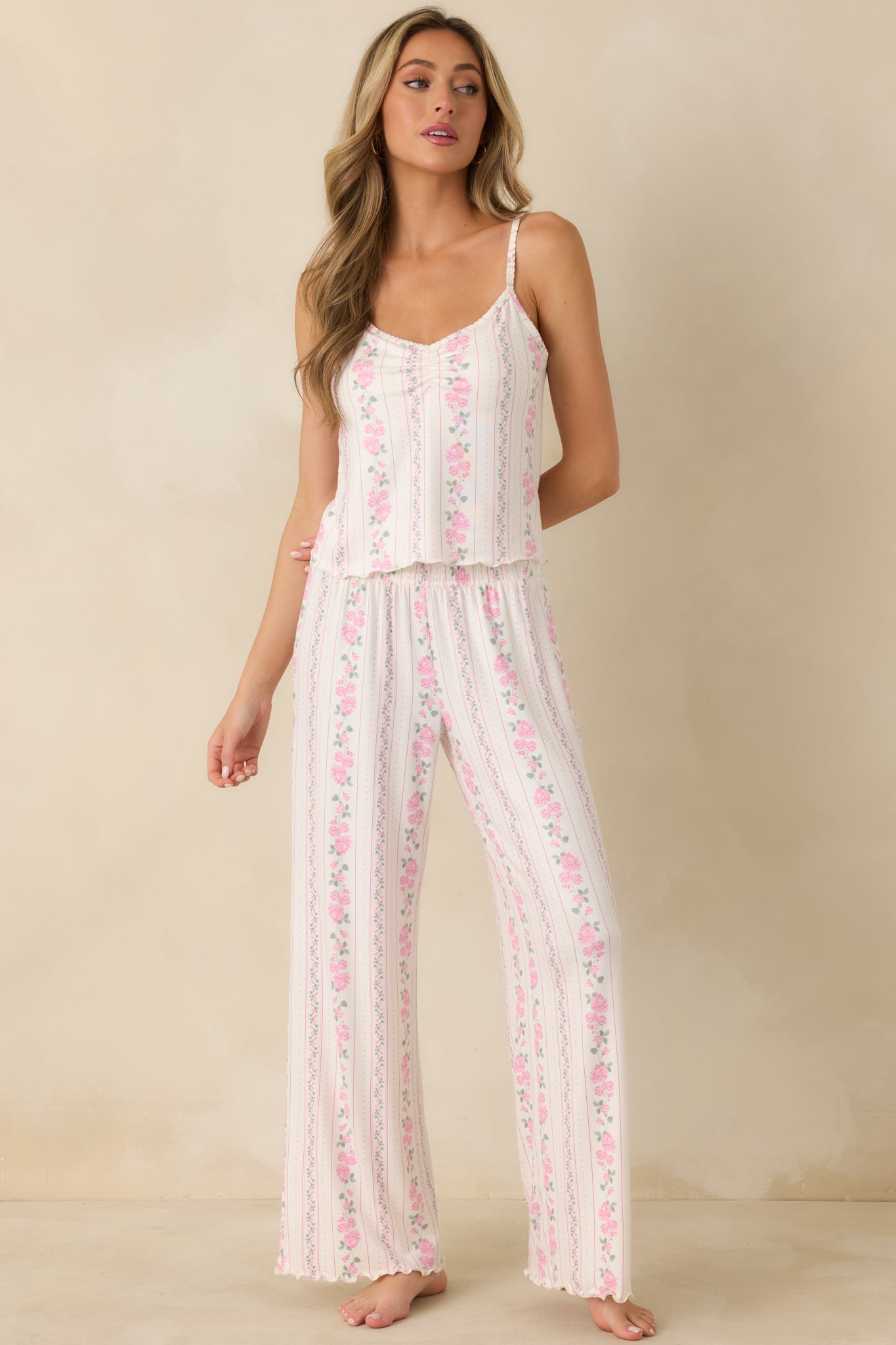 Ivory floral stripe cami designed with a gathered sweetheart neckline and subtle ruffle trim along the hem.