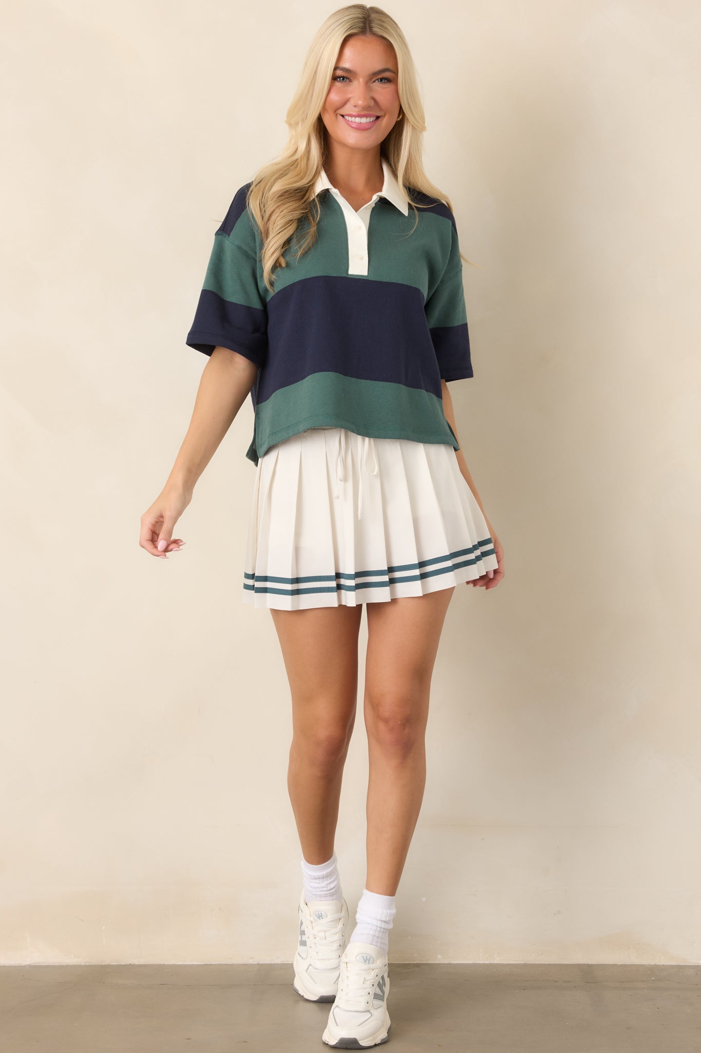 Ivory athletic skirt with Emerald Cove stripes along the lower hem, a secure drawcord waistband, built-in biker shorts, and a comfortable silhouette.