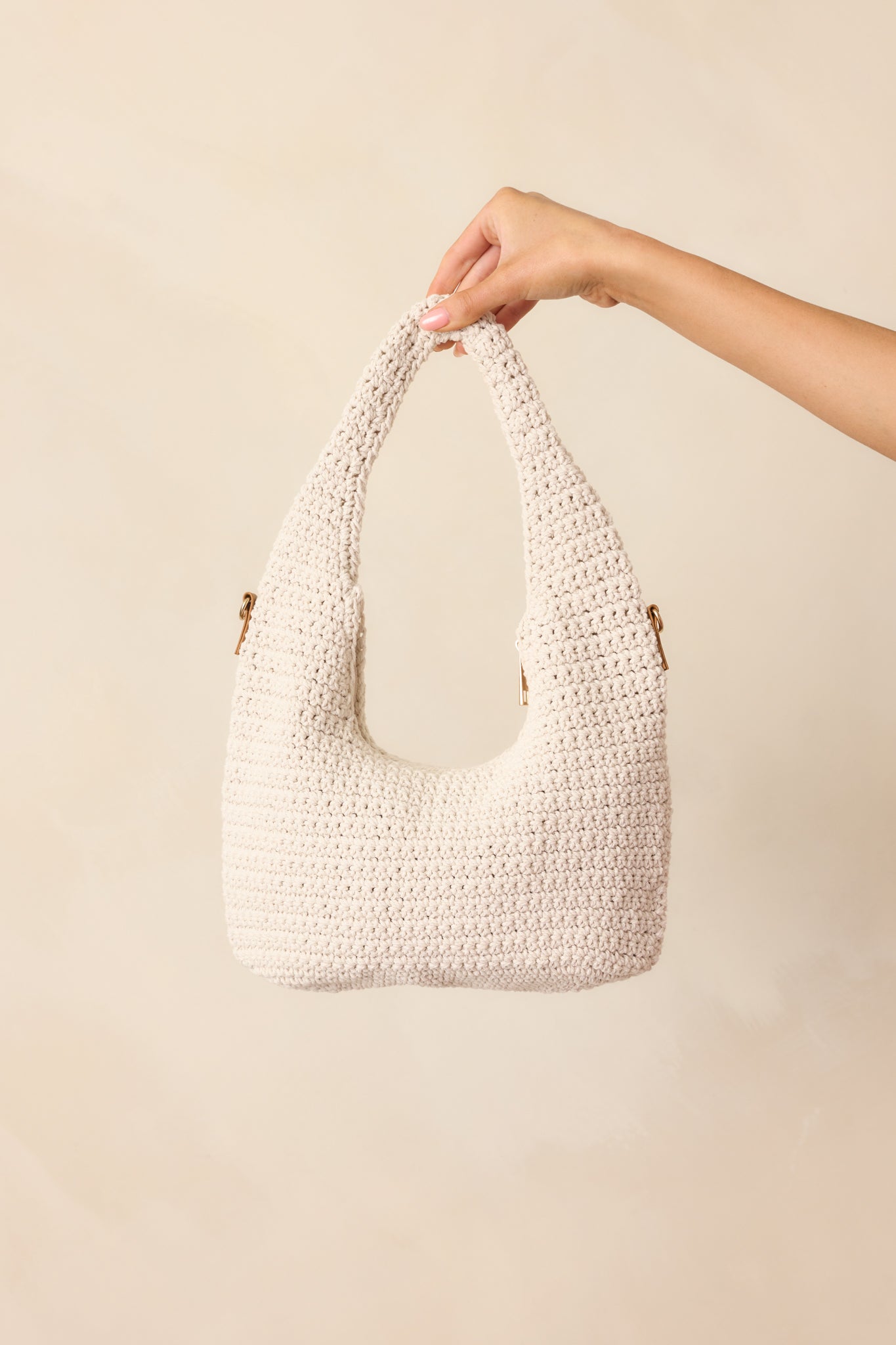 A complete profile of the ivory handbag, showcasing its intricate woven design and golden zippers.