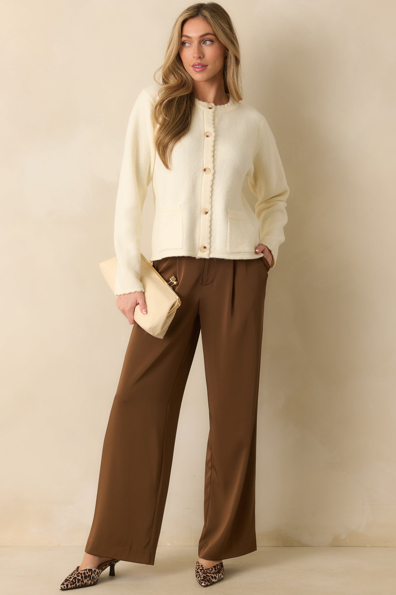 A front-facing photo displaying the relaxed fit and buttoned front of the ivory knit cardigan.