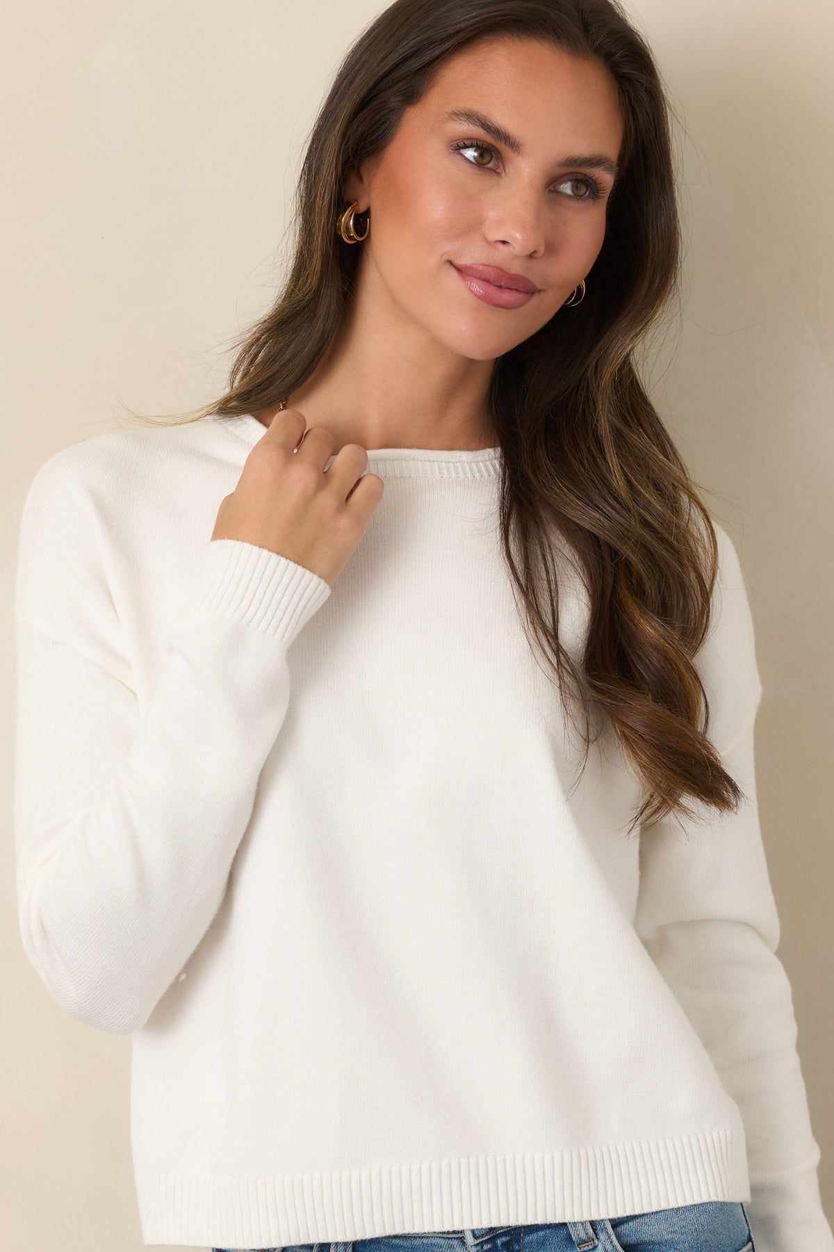 Ivory knit construction showcases the clean crew neckline and softly relaxed shoulders.