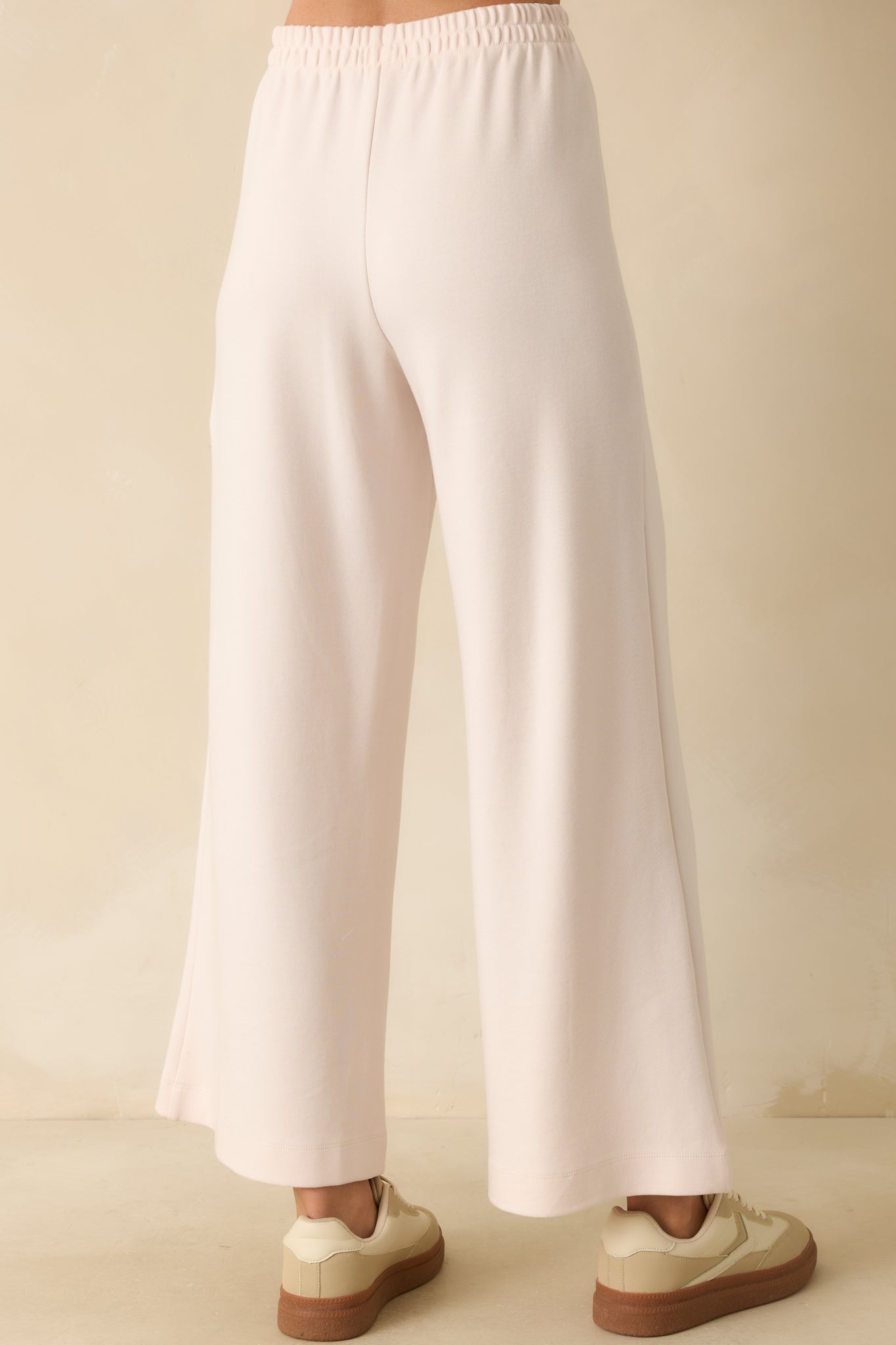 Rear view of ivory knit pants showing wide-leg cut, elastic waistband, and relaxed fit.