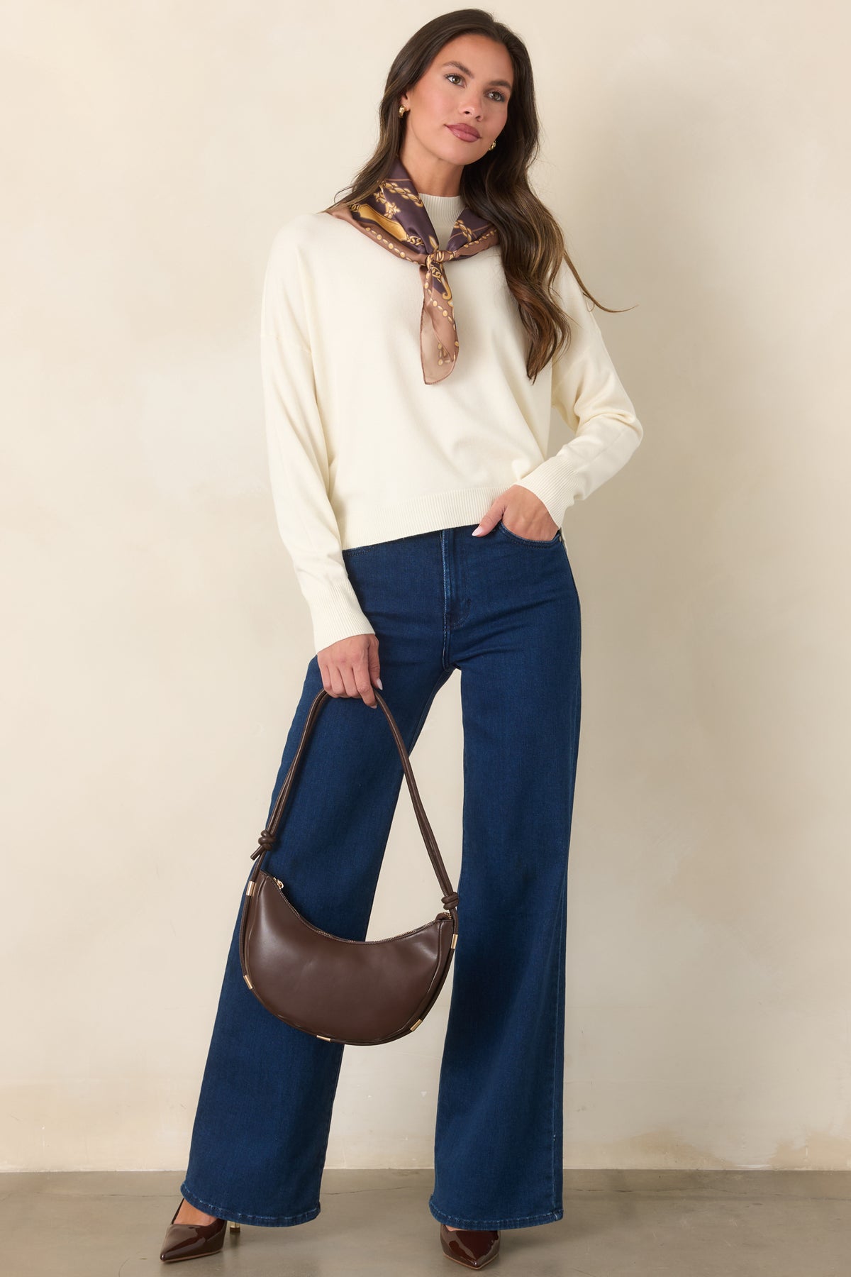 Ivory knit pullover featuring a ribbed mock neckline, dropped shoulders, long sleeves, and a relaxed silhouette.