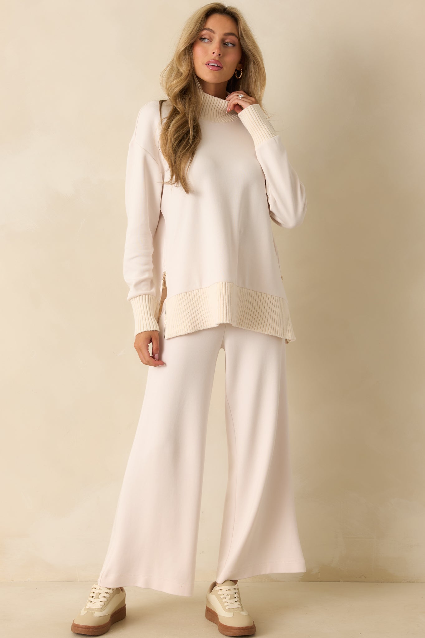 Soft ivory knit sweater with long sleeves and ribbed trim throughout for a polished look.