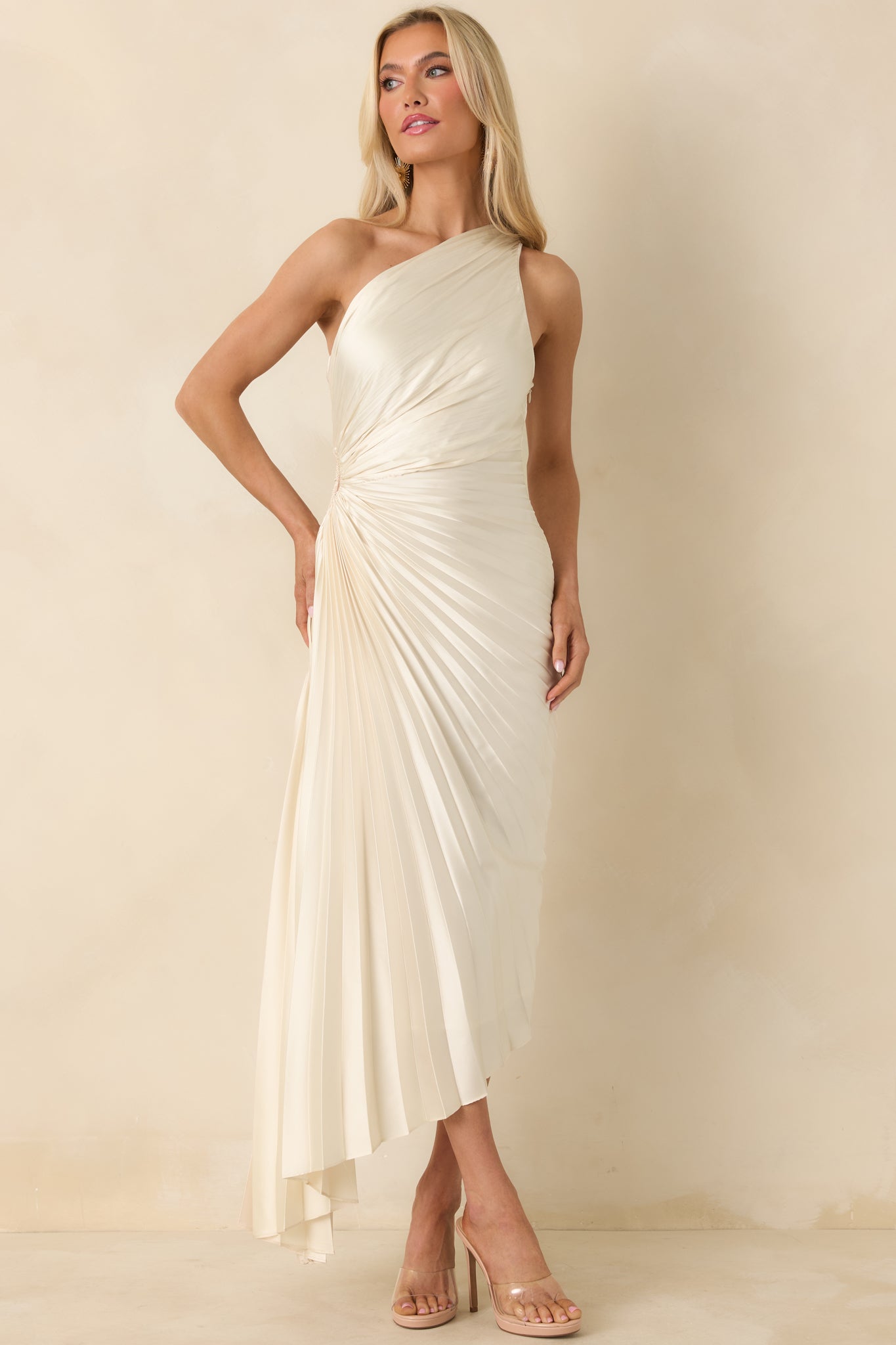 Flowing ivory maxi dress highlighting the pleated skirt, asymmetric neckline, and smooth drape.