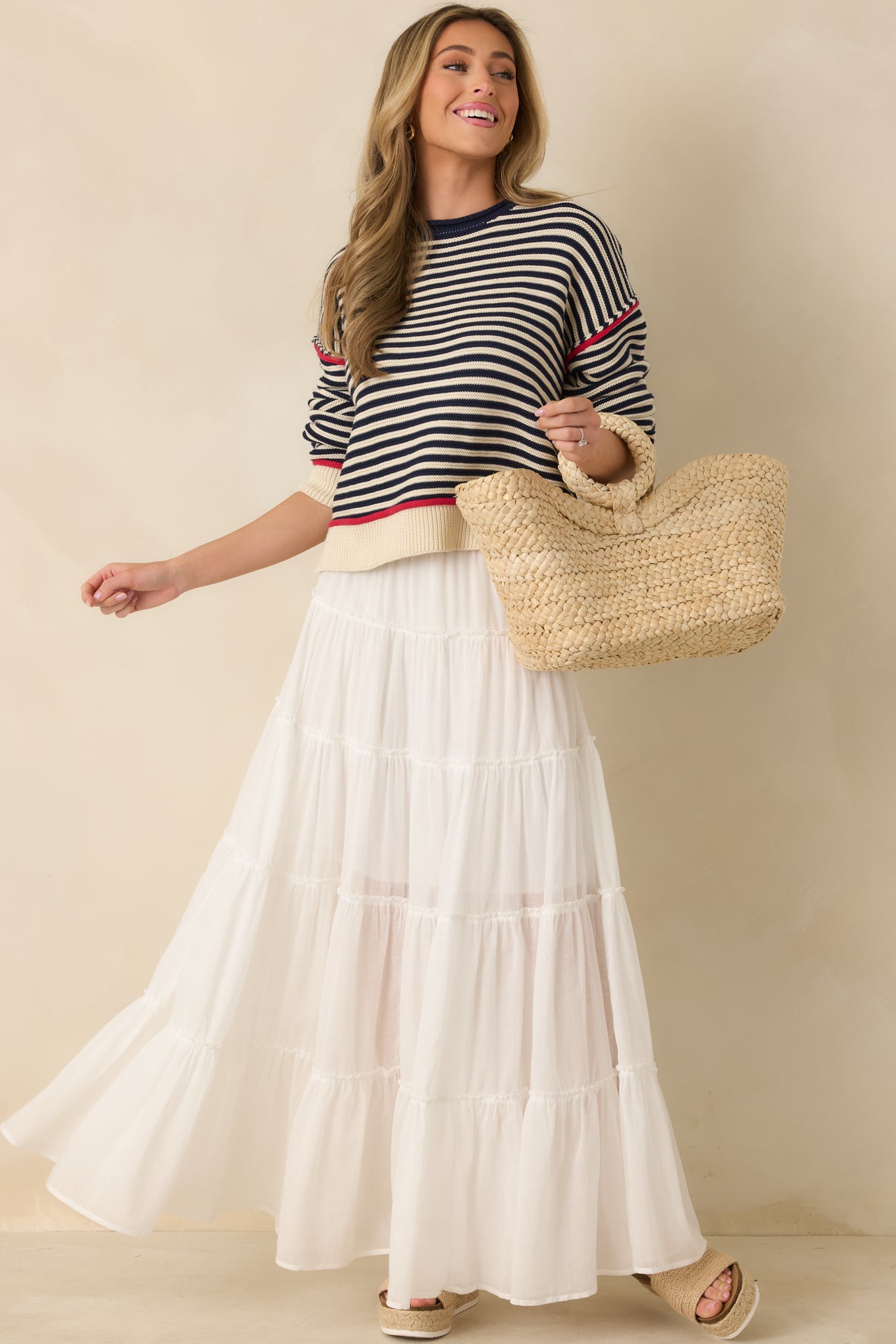 Ivory maxi skirt with elastic waistband, adjustable drawstring tie with bead accents, and multi-tiered flowing silhouette.