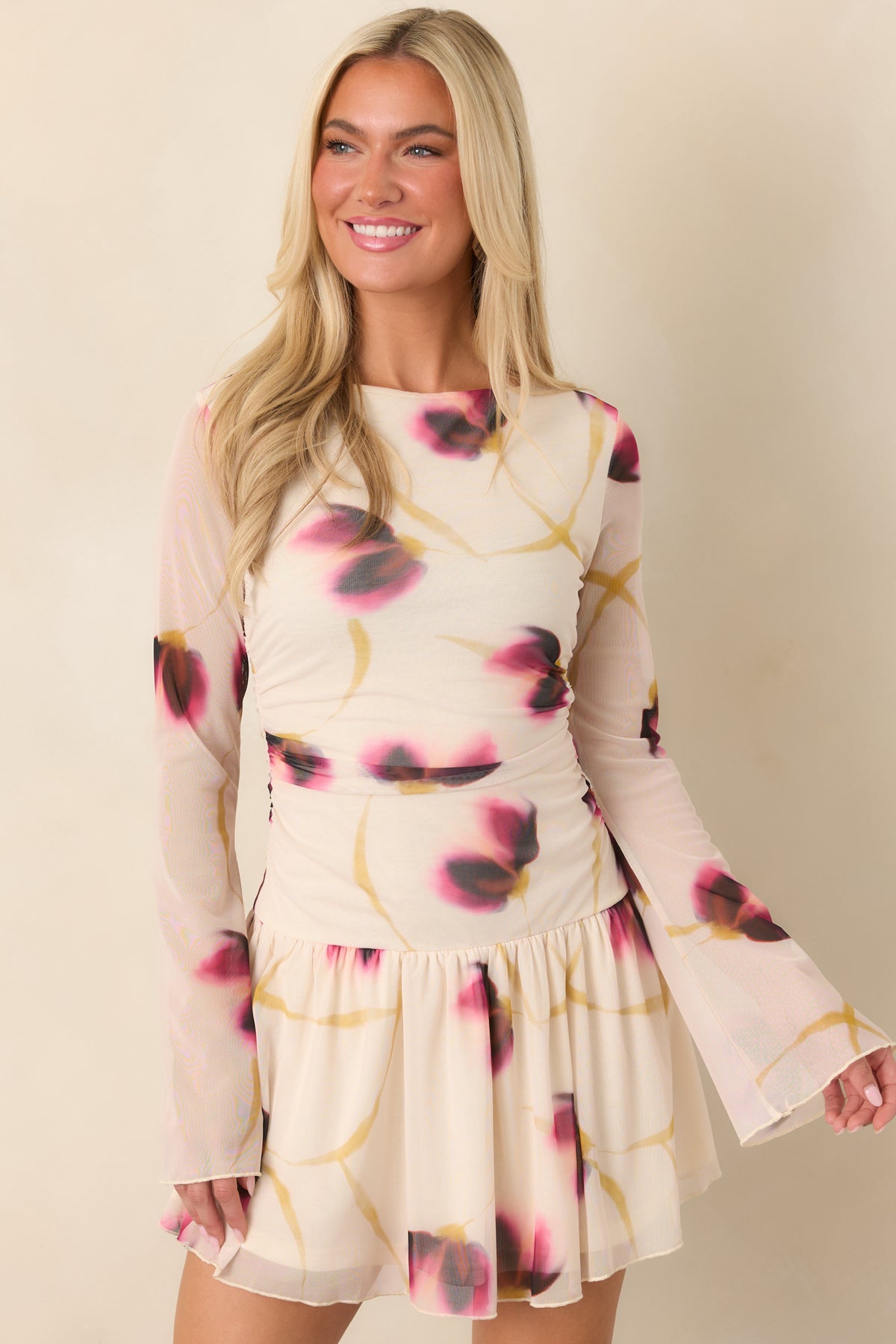 Wine, pink, and golden floral accents decorate the ivory mesh dress, highlighting its gathered waist and fitted shape.