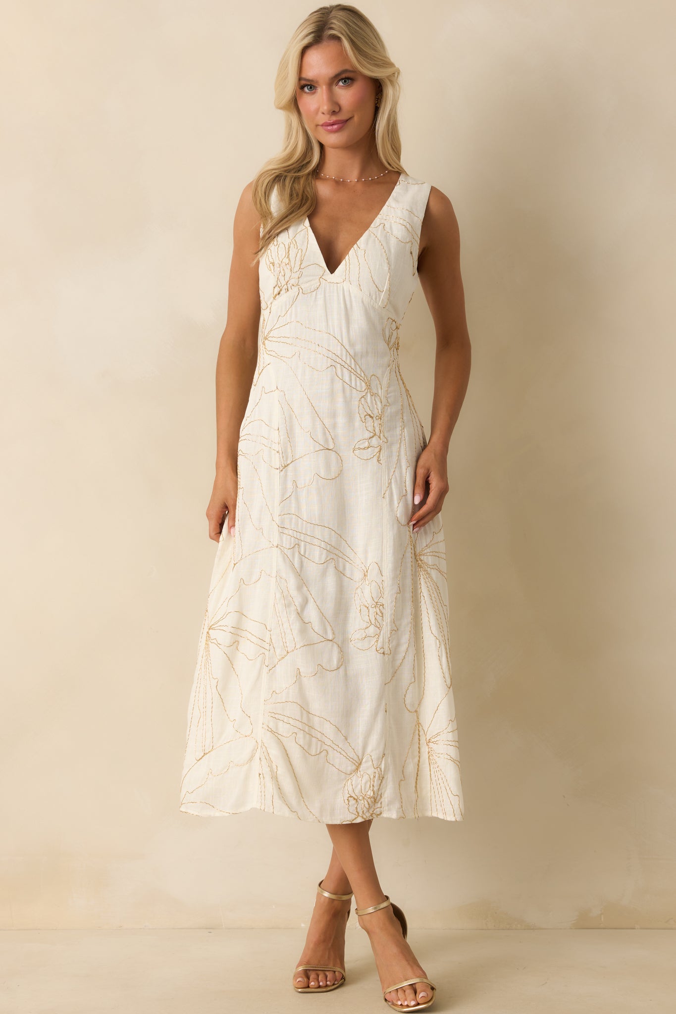 Ivory midi dress with golden beaded floral embroidery and a deep v-neckline.