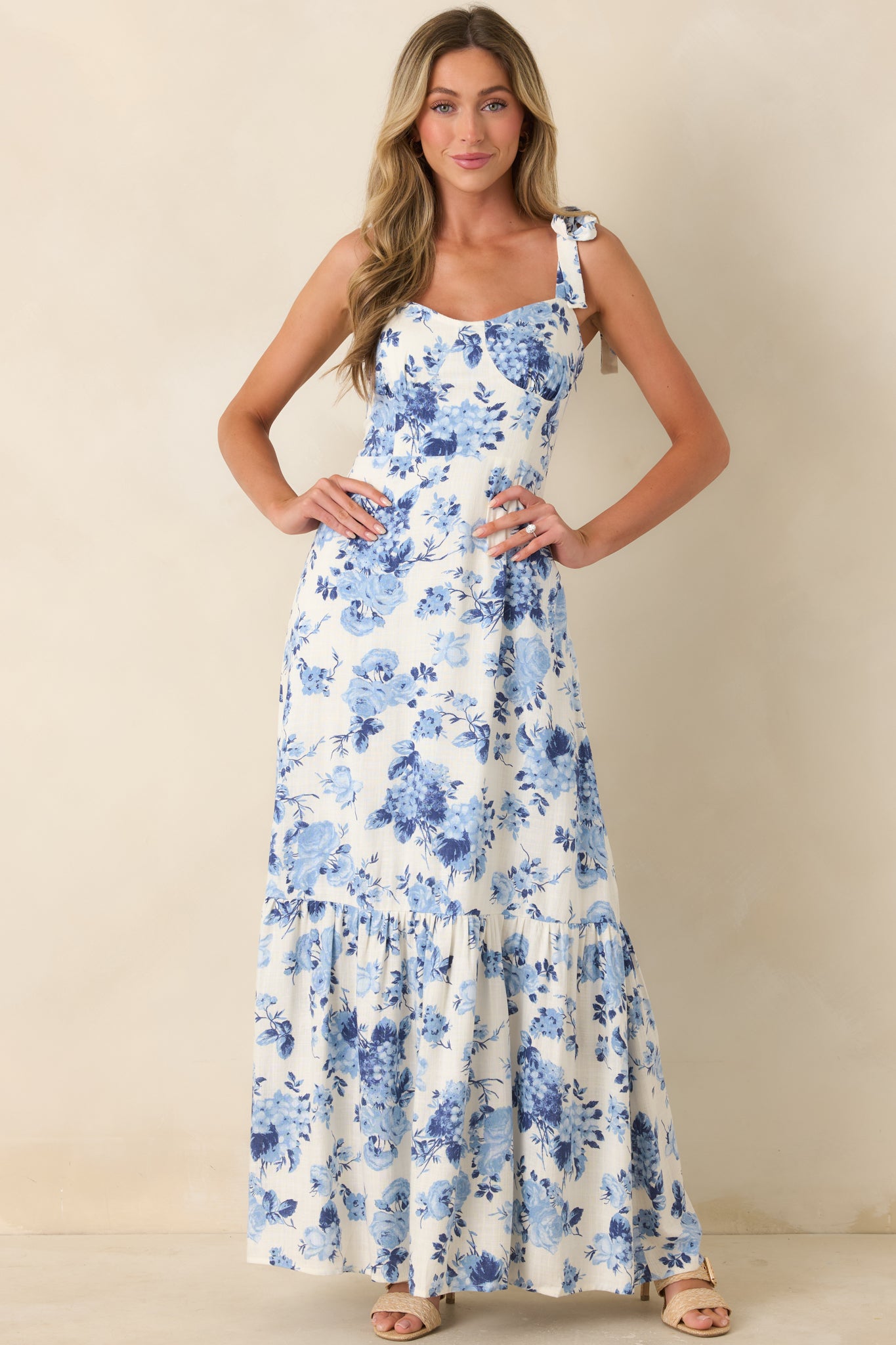 Ivory midi dress with painterly blue florals and fitted bodice silhouette.