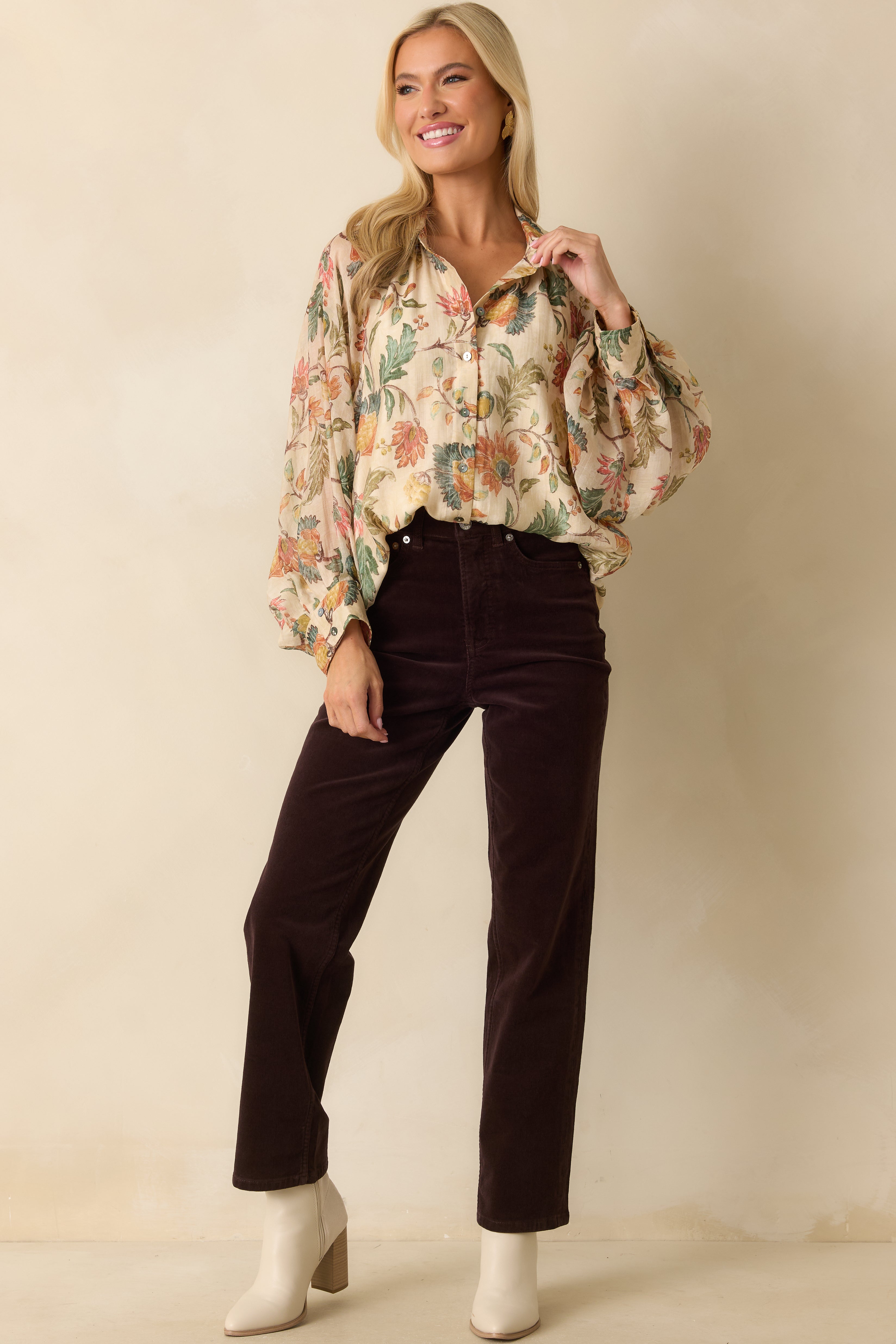 Ivory multi floral blouse with collared neckline, button-front closure, and long peasant sleeves.