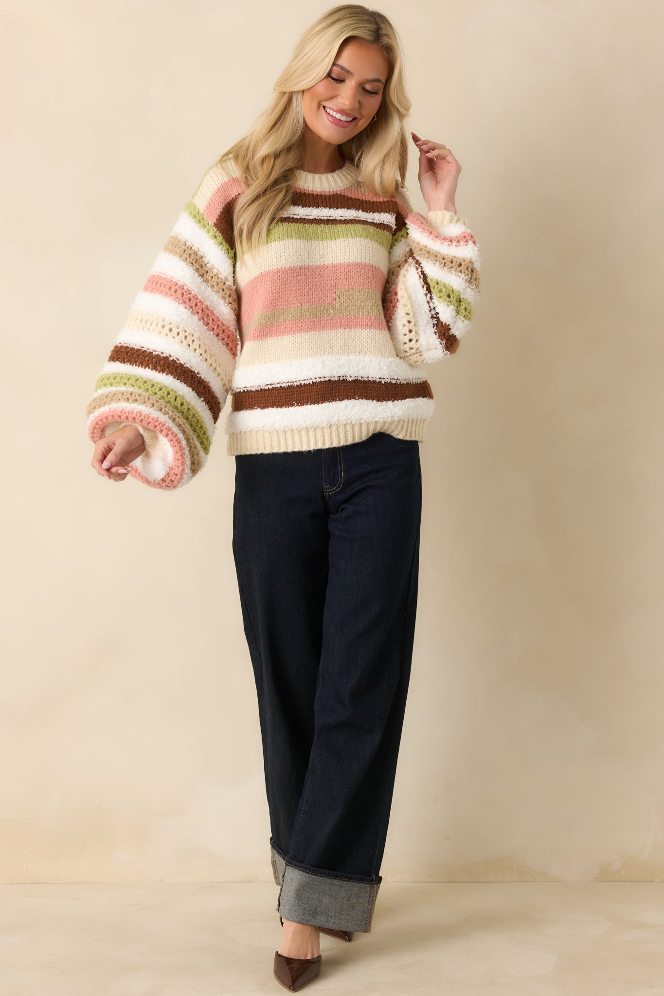Ivory oversized striped sweater with multi-color horizontal stripes, relaxed fit, ribbed crew neckline, and long balloon sleeves.
