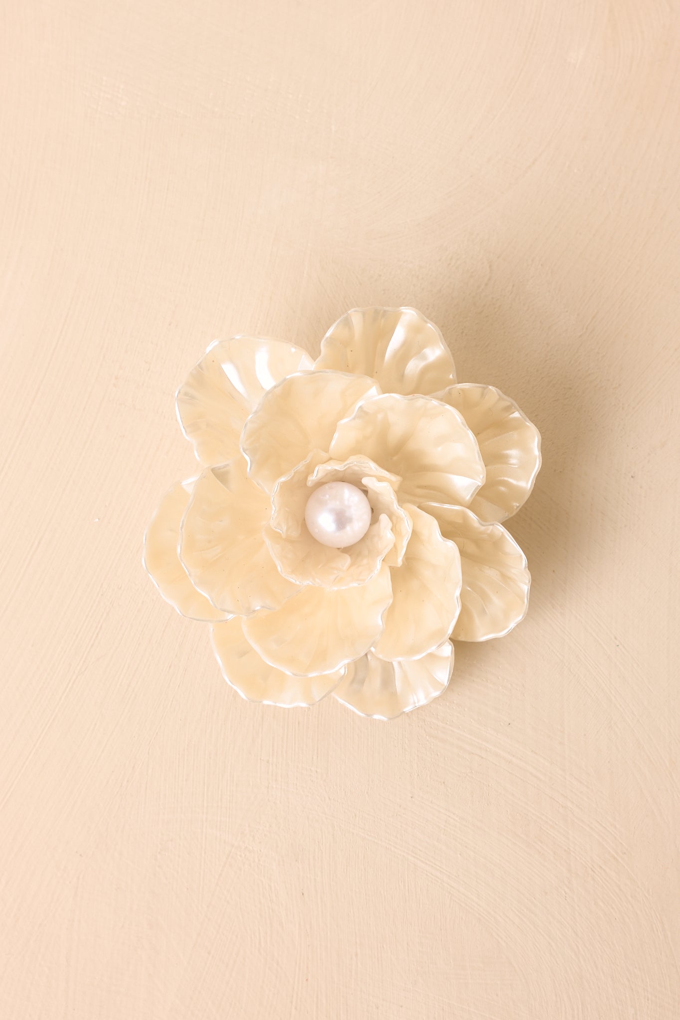Ivory floral accessory featuring layered petal-shaped details, glossy pearlescent finish, and center faux pearl accent.