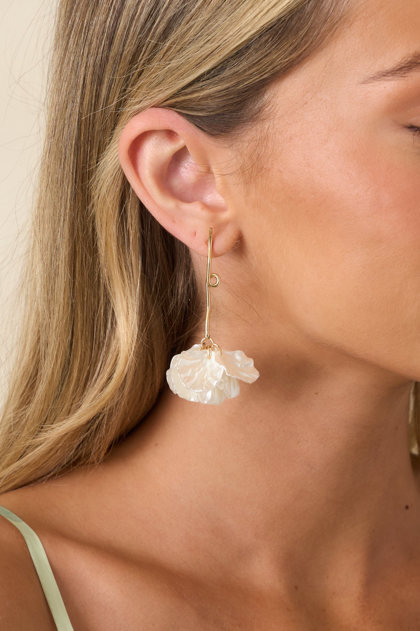 Elegant earrings showcasing layered ivory leaf-shaped petals, gold hardware, and a lightweight dangling silhouette.