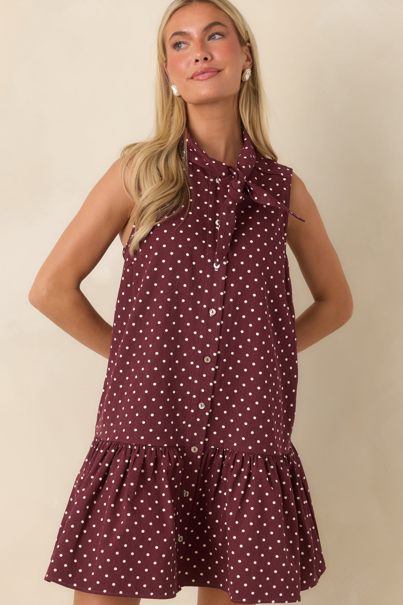 Ivory polka dot mini dress showcasing the relaxed silhouette, drop waist, and gathered ruffle hem.