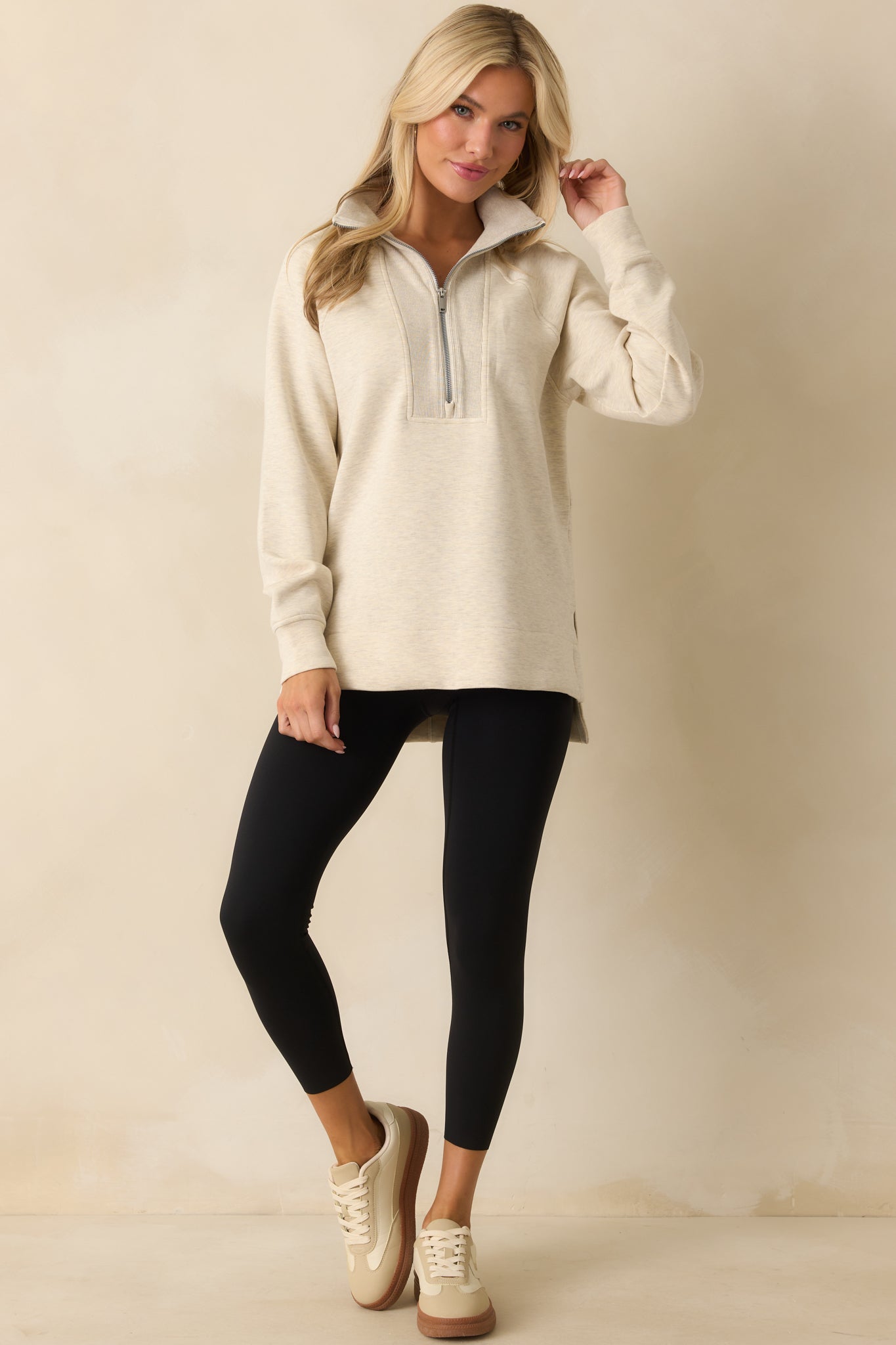 Ivory pullover with a relaxed tunic-length fit and stand collar design.