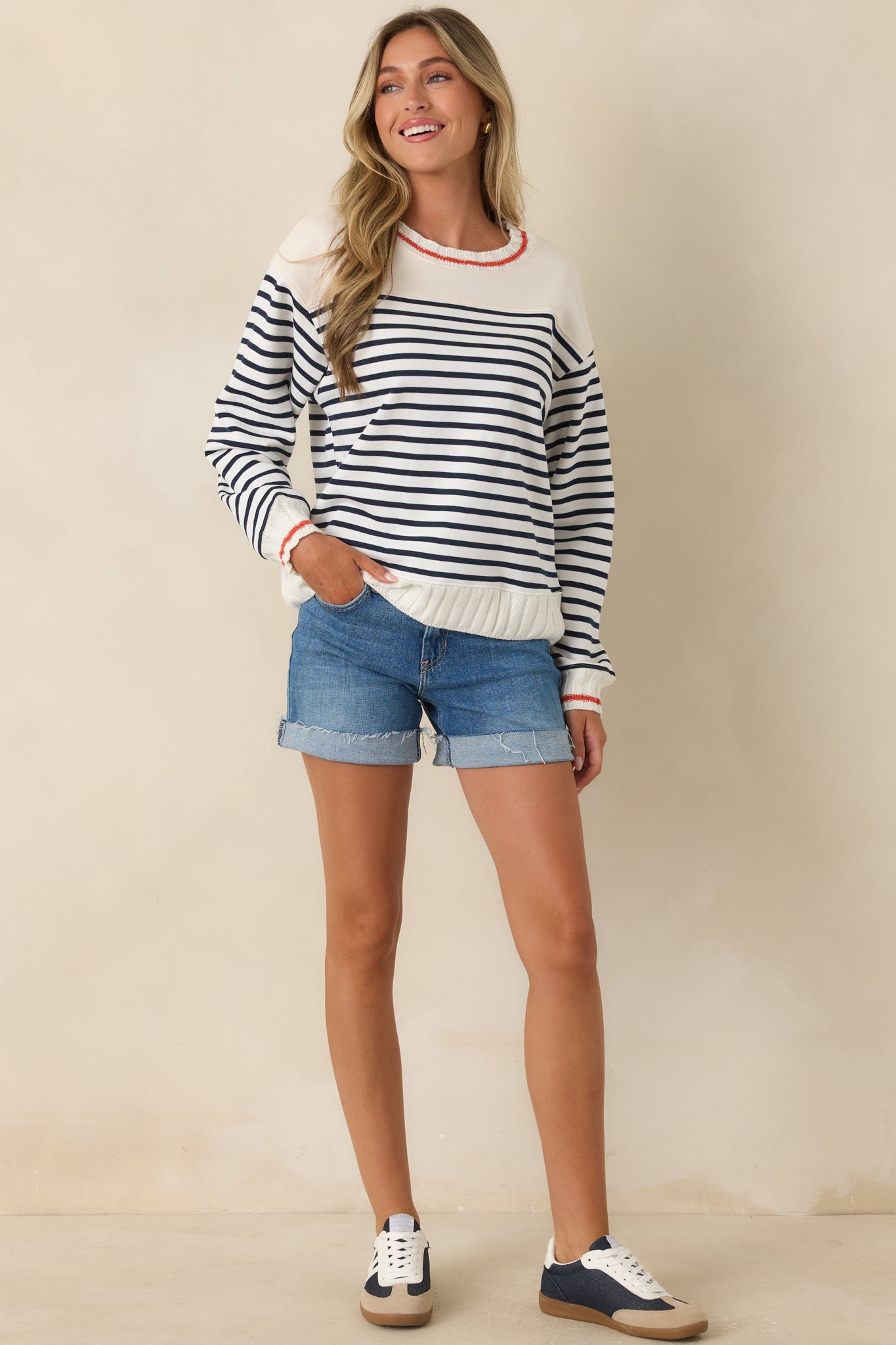 Ivory pullover featuring classic navy stripes, contrast shoulder panels, and a relaxed silhouette.