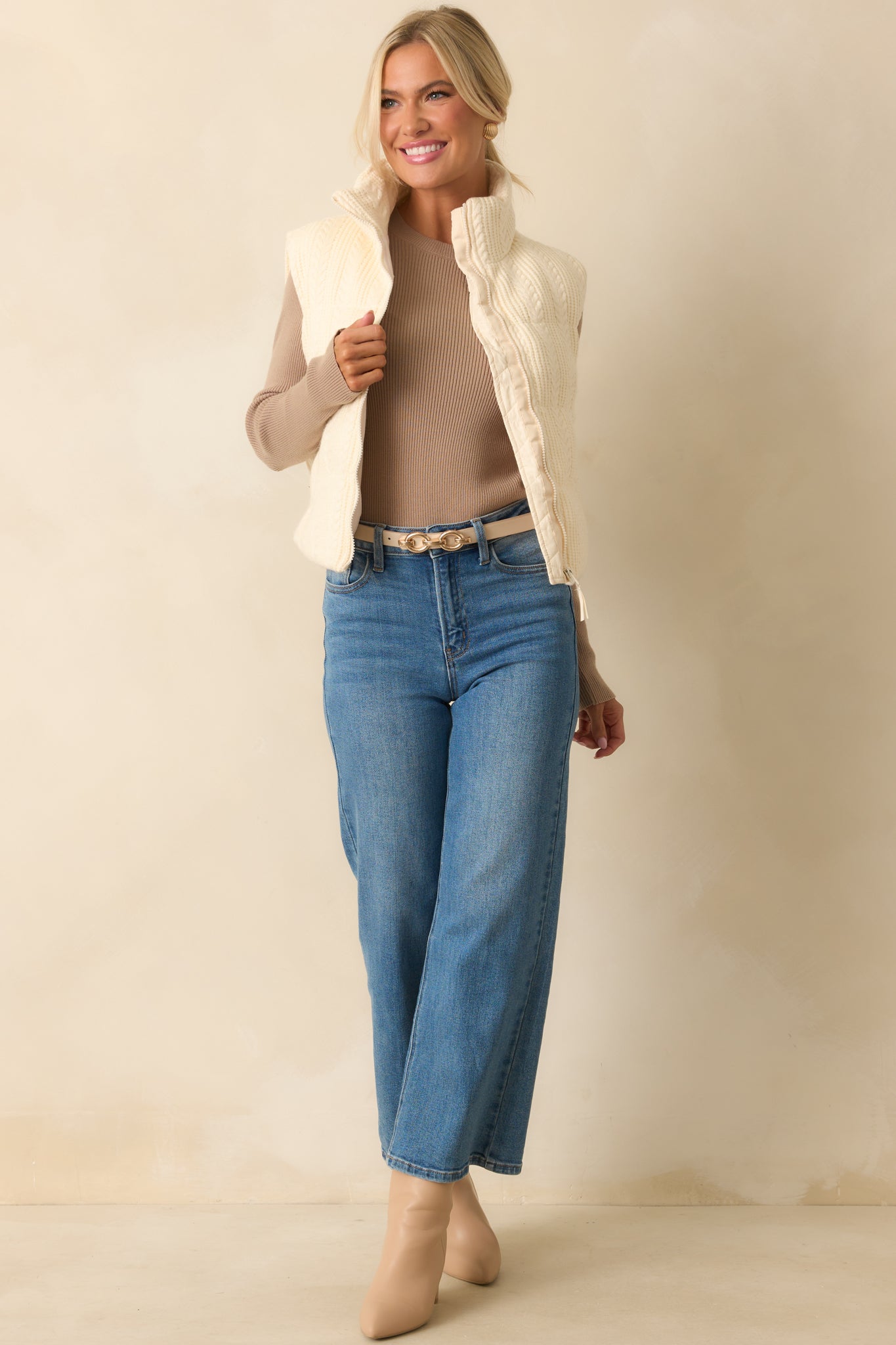 Ivory quilted vest with functional pockets and relaxed silhouette.