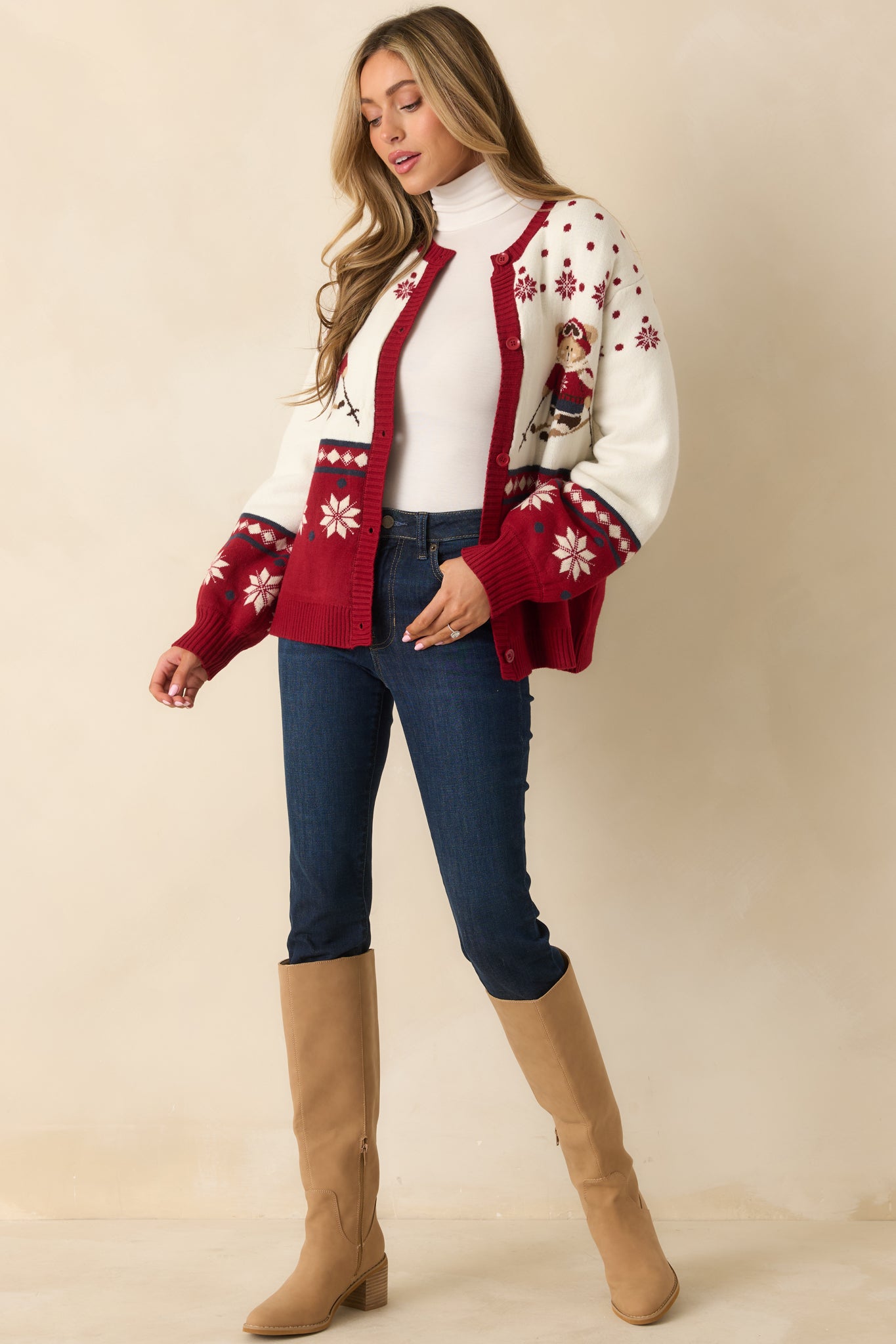 Ivory and red cardigan showing its easy, relaxed shape with bold seasonal knit-in motifs throughout.