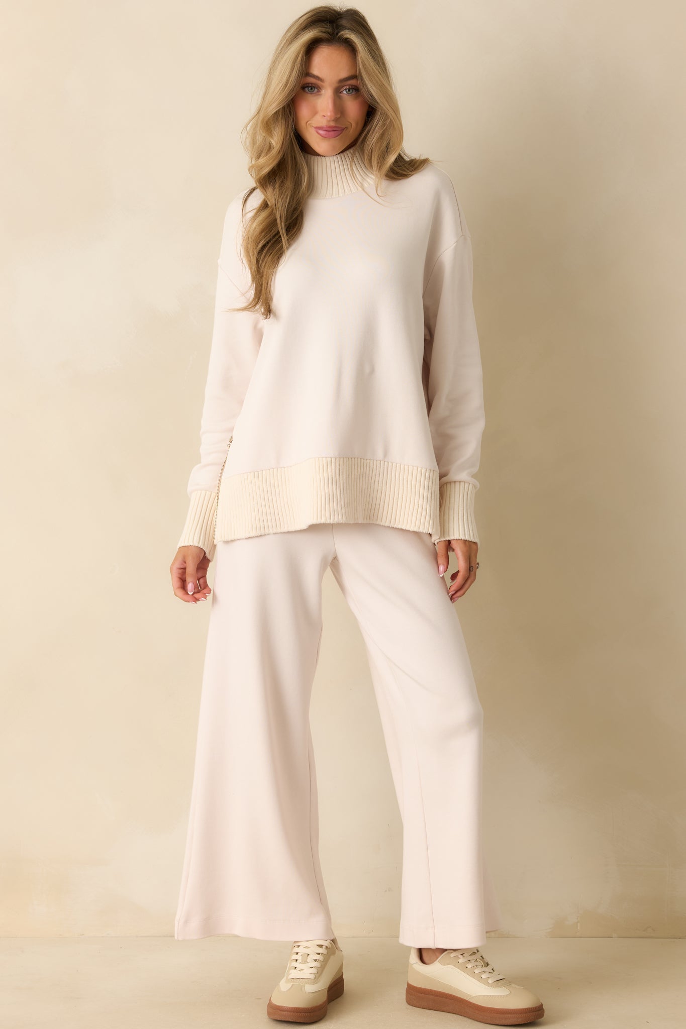 Ivory ribbed mock neck sweater with cozy relaxed silhouette and subtle texture.