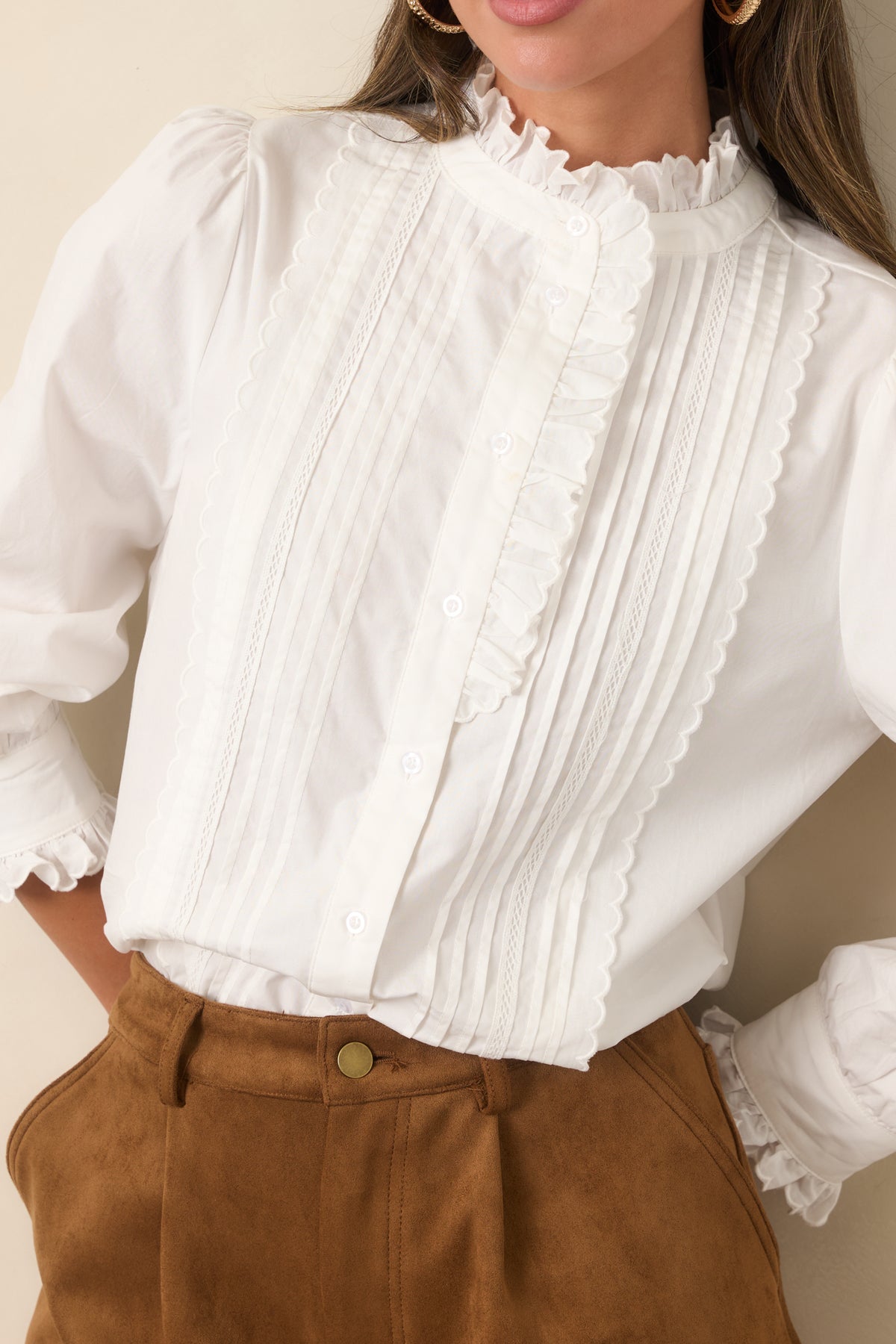 Close-up detail highlighting the ruffled neckline, pintuck detailing, and functional front buttons.