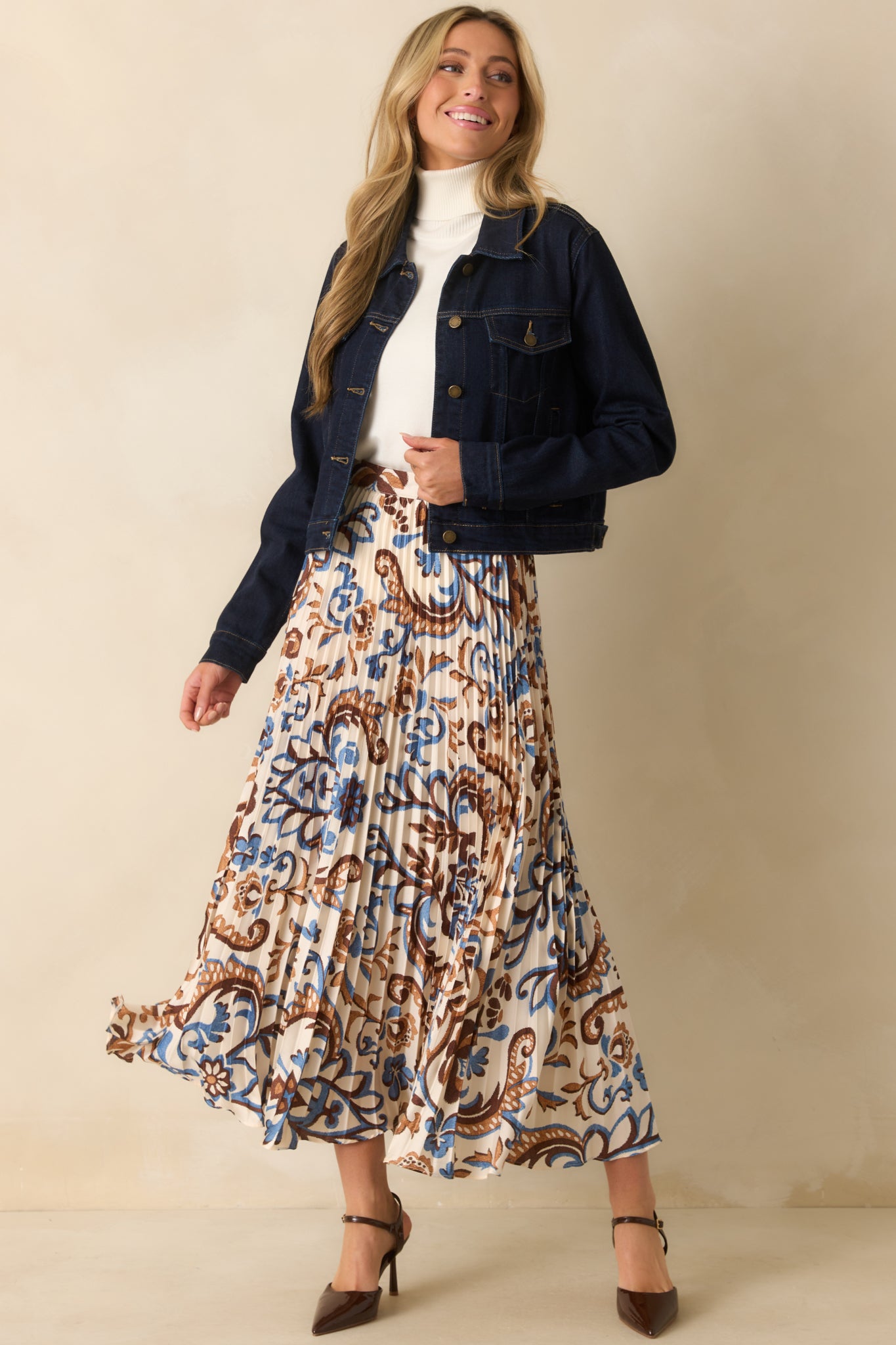 Ivory maxi skirt with pleated satin finish and allover paisley floral design in blue and brown.