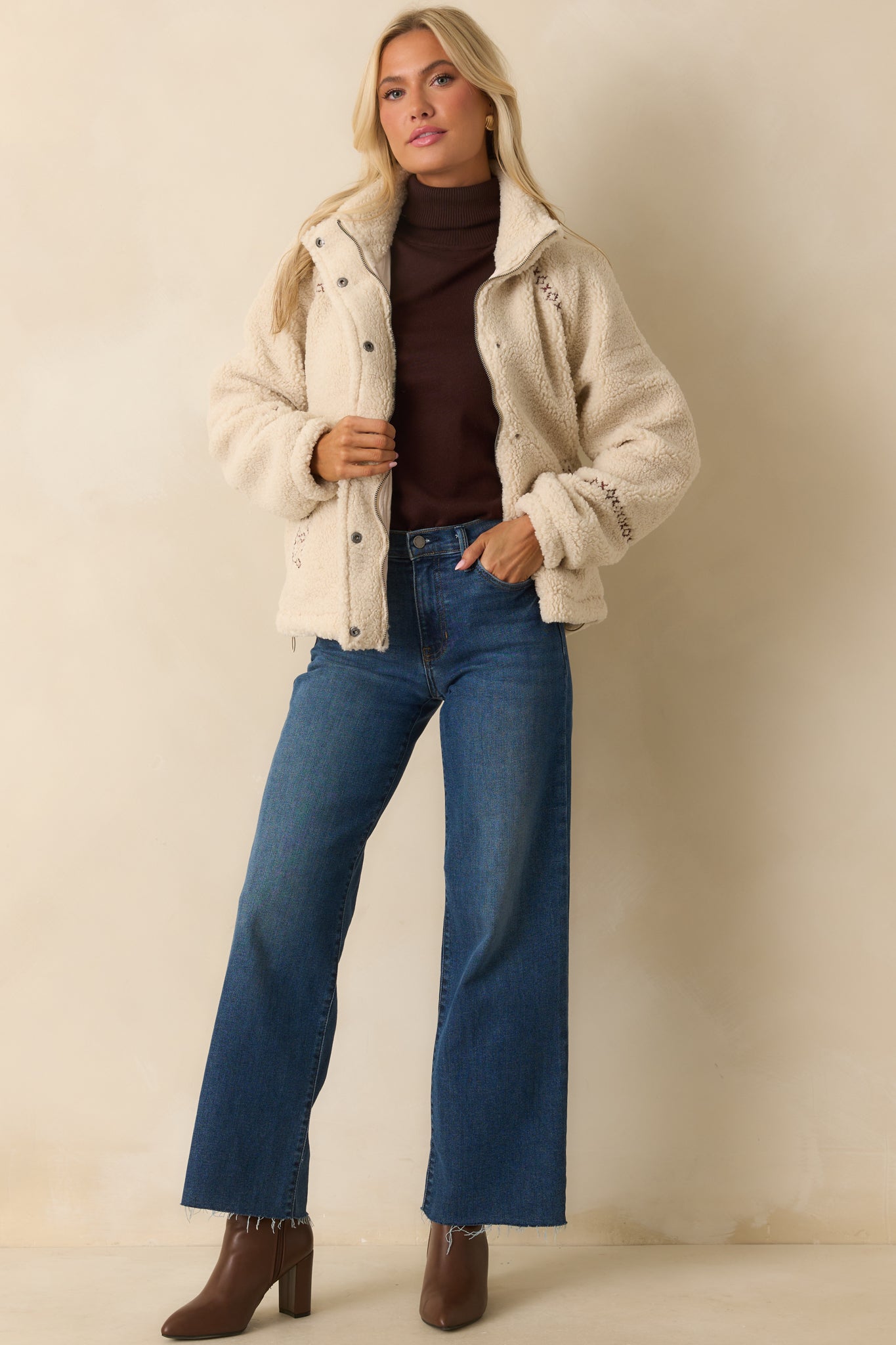 Ivory sherpa jacket with stand collar, long sleeves, and full zip front with additional snap button closure.