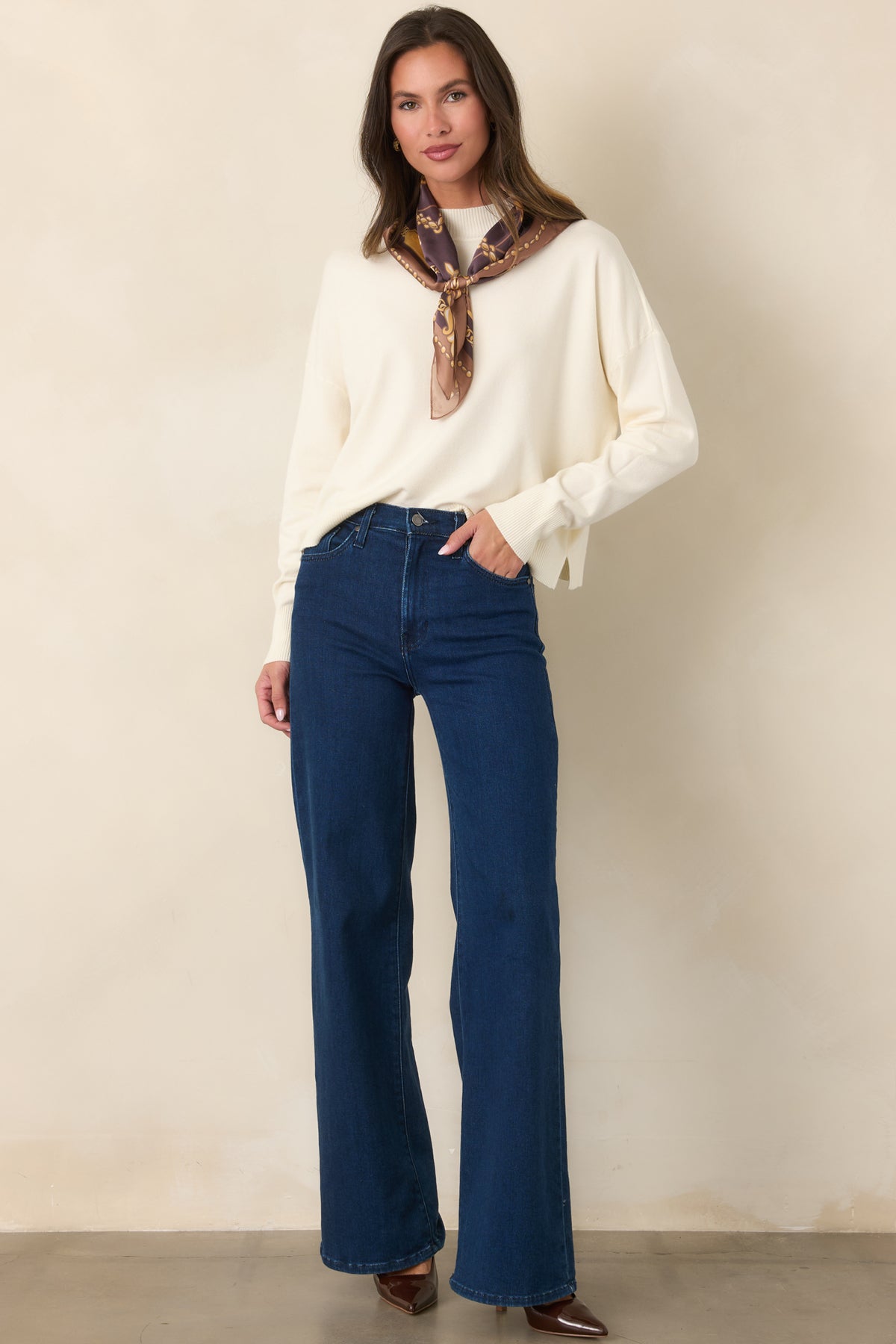 Soft ivory pullover showcasing a smooth knit texture, long sleeves, and a structured mock neckline.