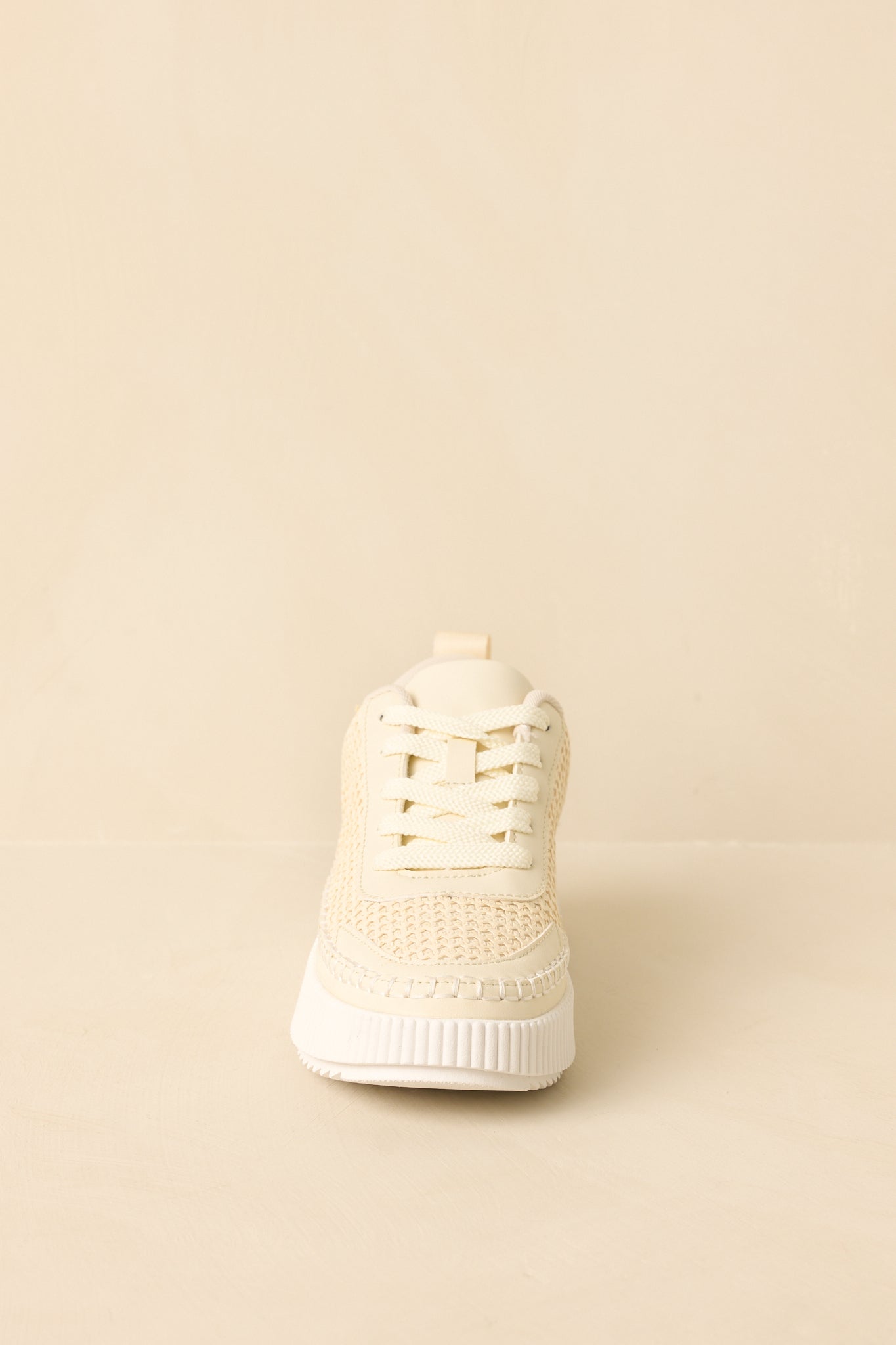 Ivory sneakers showing the toe shape, knit pattern, and clean lace arrangement.