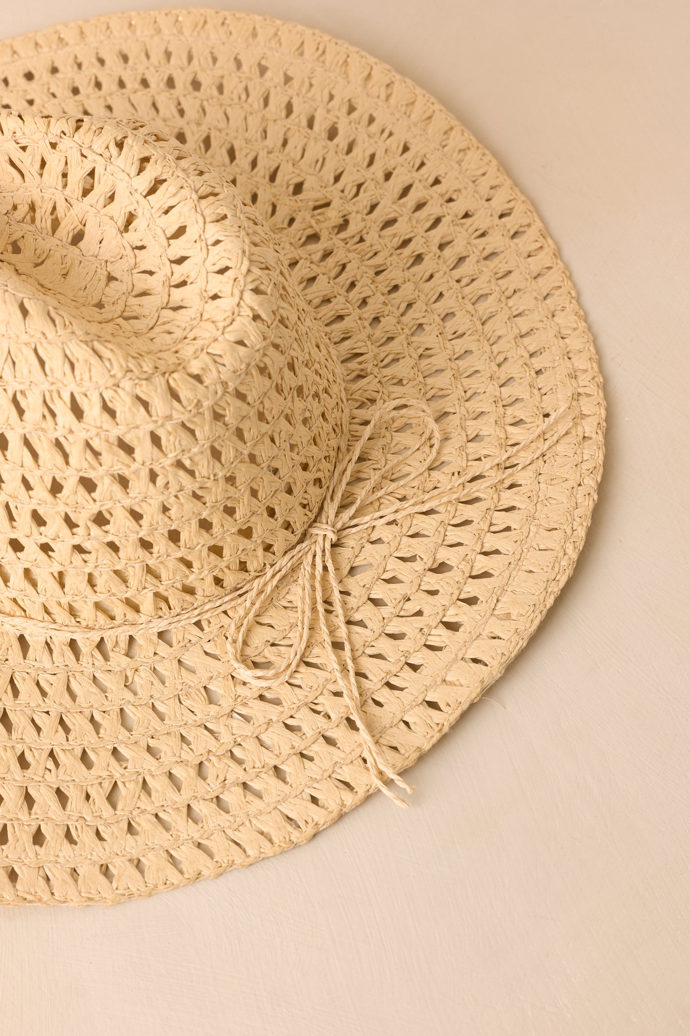 Ivory straw cowboy hat highlighting its relaxed texture, wide brim, and timeless Western silhouette.