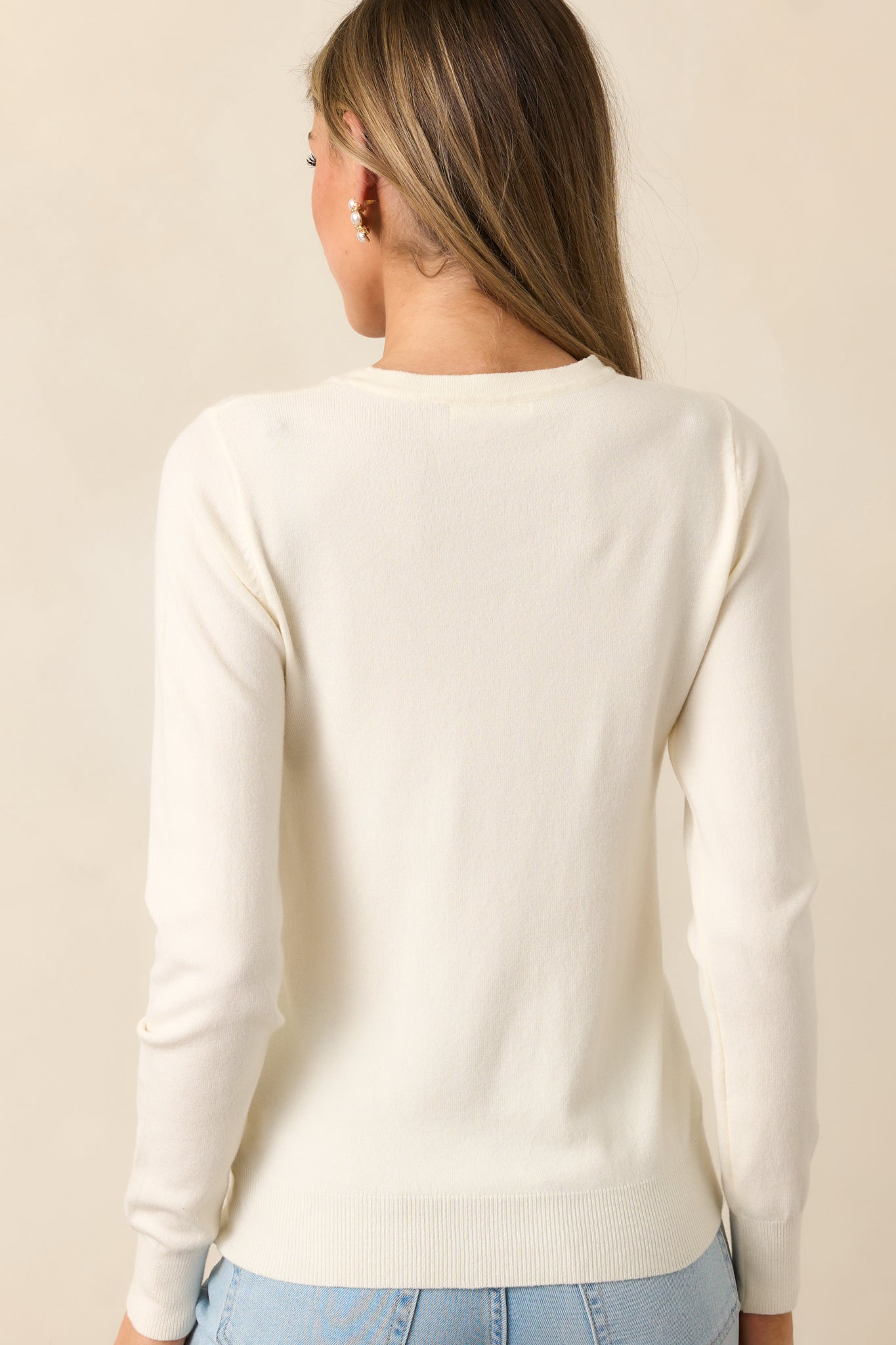 This Ivory sweater features a rounded crew neckline, relaxed fit, rib knit hems, and long sleeves.