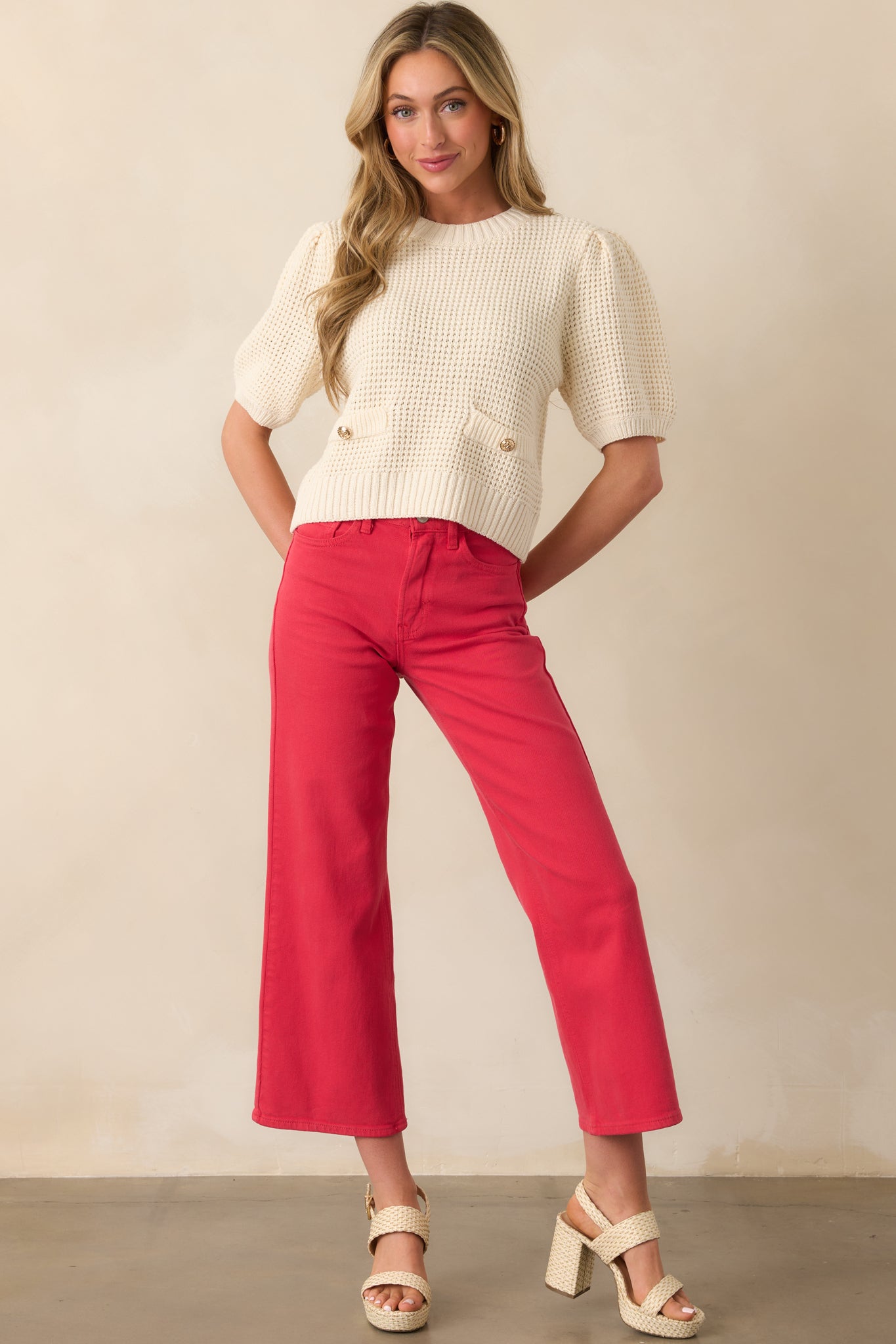 Ivory sweater with short puff sleeves and decorative buttons, styled to highlight its classic shape and structure.
