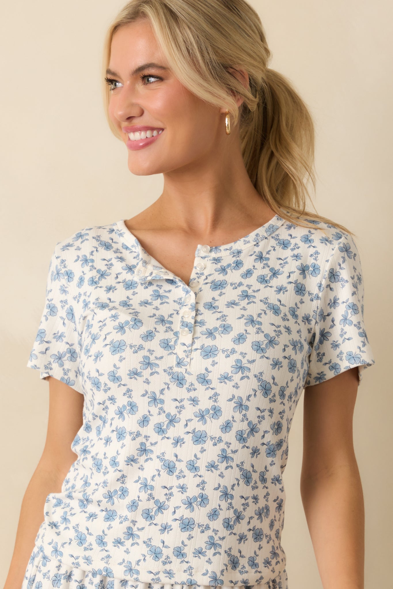 Blue floral pattern set against the ivory backdrop with neat short sleeves.